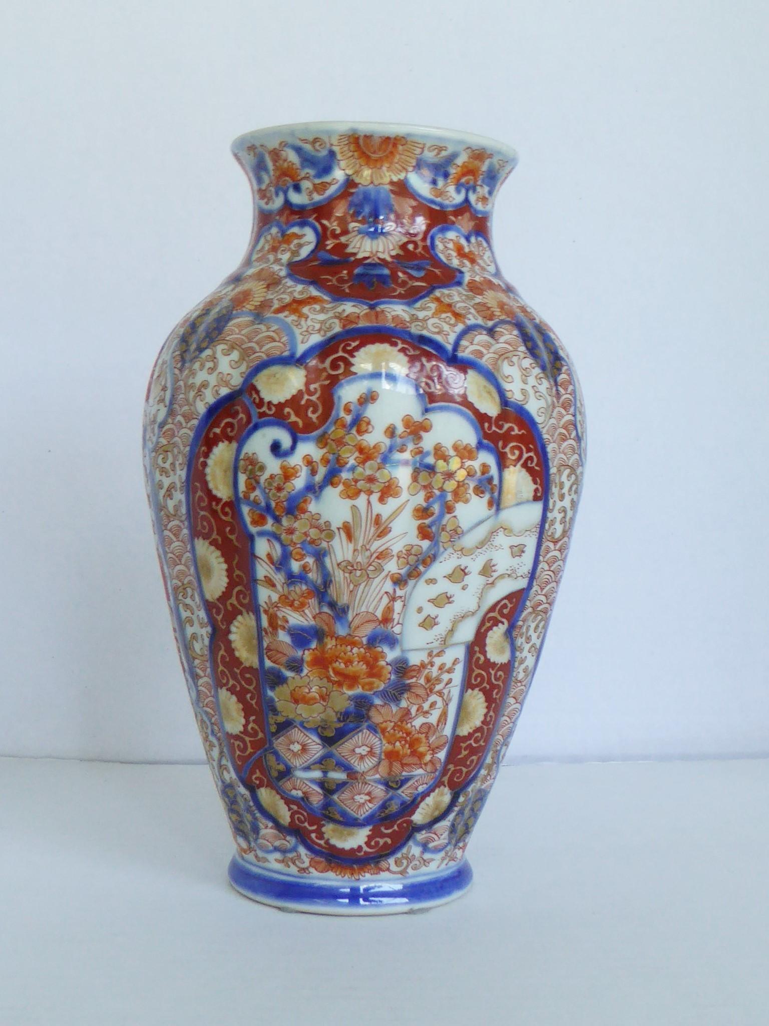 Lovely Japanese Edo Period (1603-1867) Imari Porcelain Vase in a European form. Created with a vertical scalloped surface, hand painted and hand thrown . Decorated with a medallion in front and one in the back with depiction of many symbols that