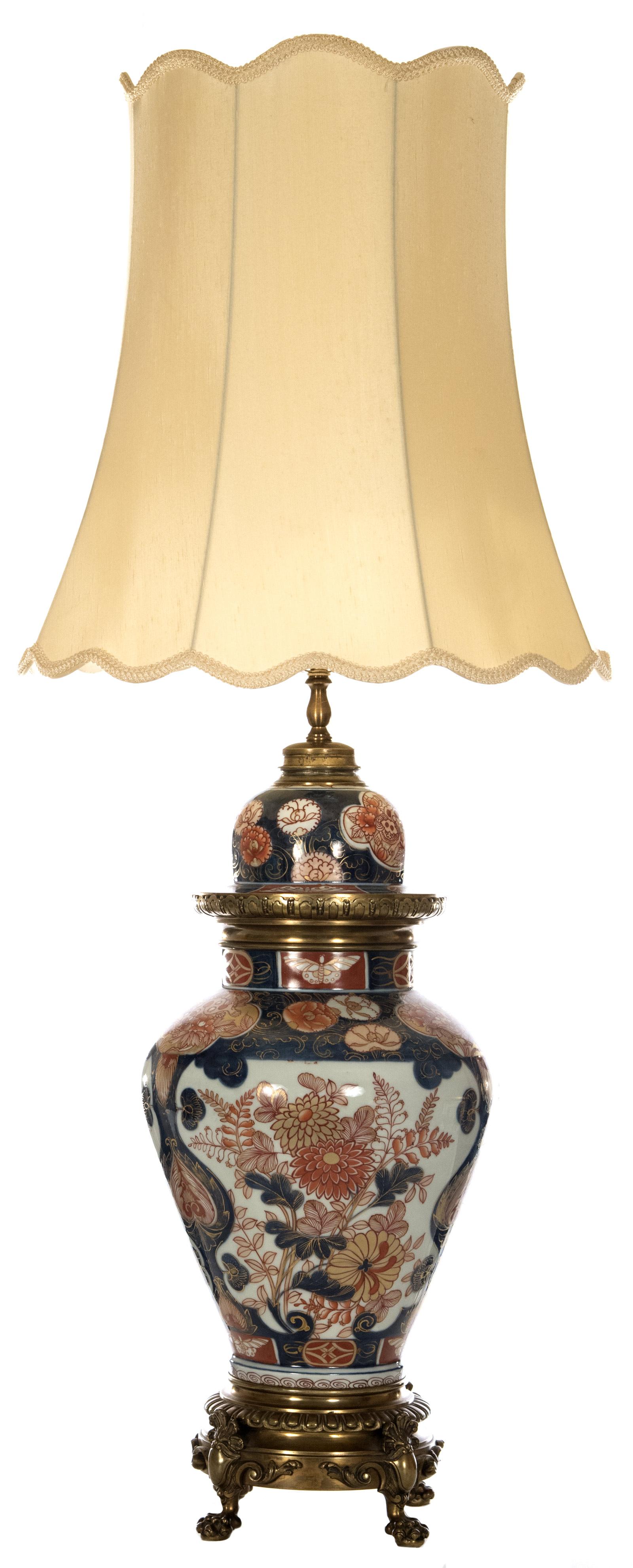 A 19th century Imari jar of baluster form on a paw-footed brass base fitted as a table lamp. The lid is decorated with a band of floral motifs and a band of alternating blue and red grounds, affixed to the body with a gadrooned brass ring. The body