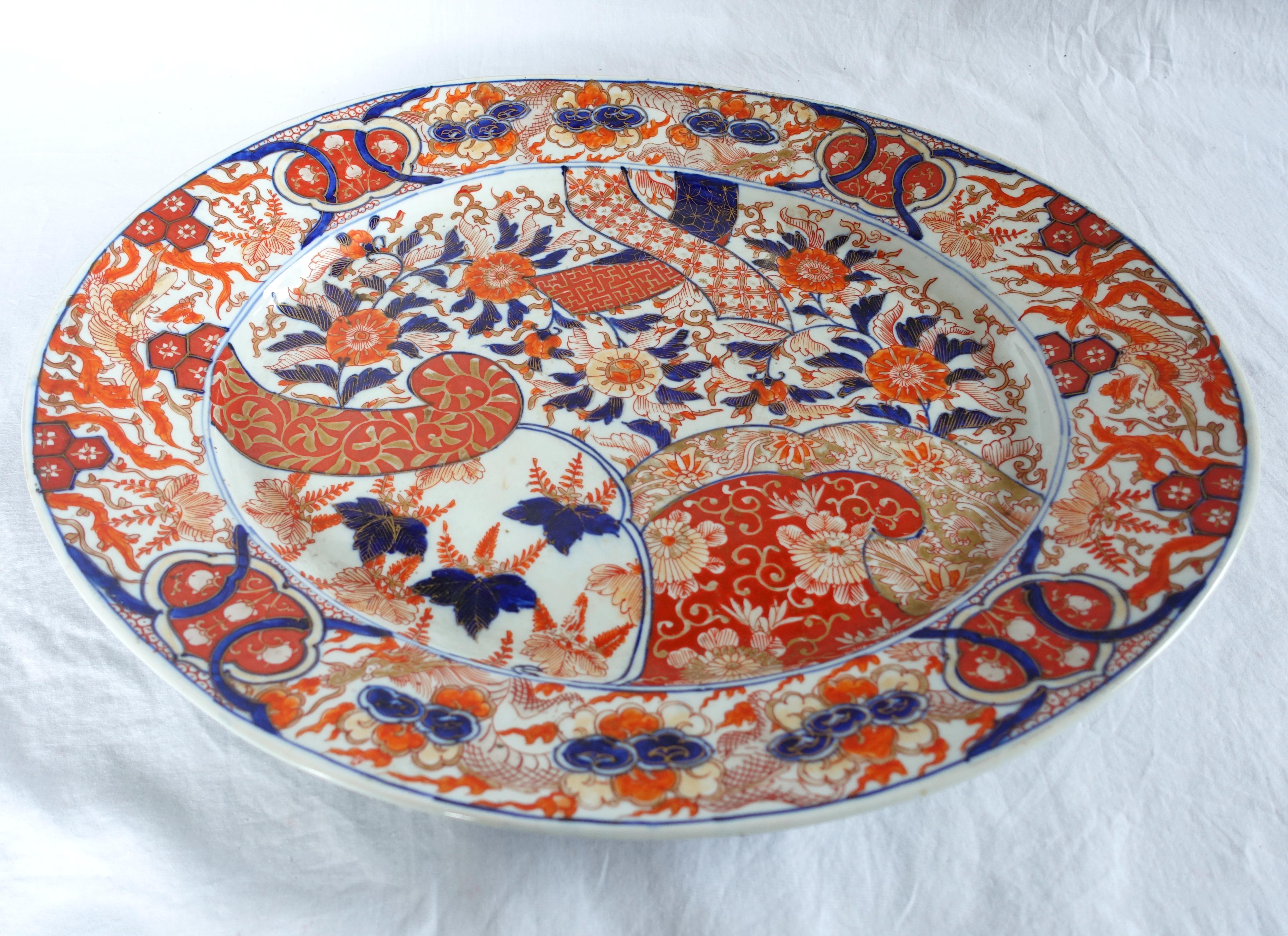 A large porcelain oval serving dish, finely decorated with classical hand-painted iron red and cobalt blue patterns enhanced with fine gold : flowers, leaves and fantastic animals including dragons.
Two marks underneath.
Japan, Imari production