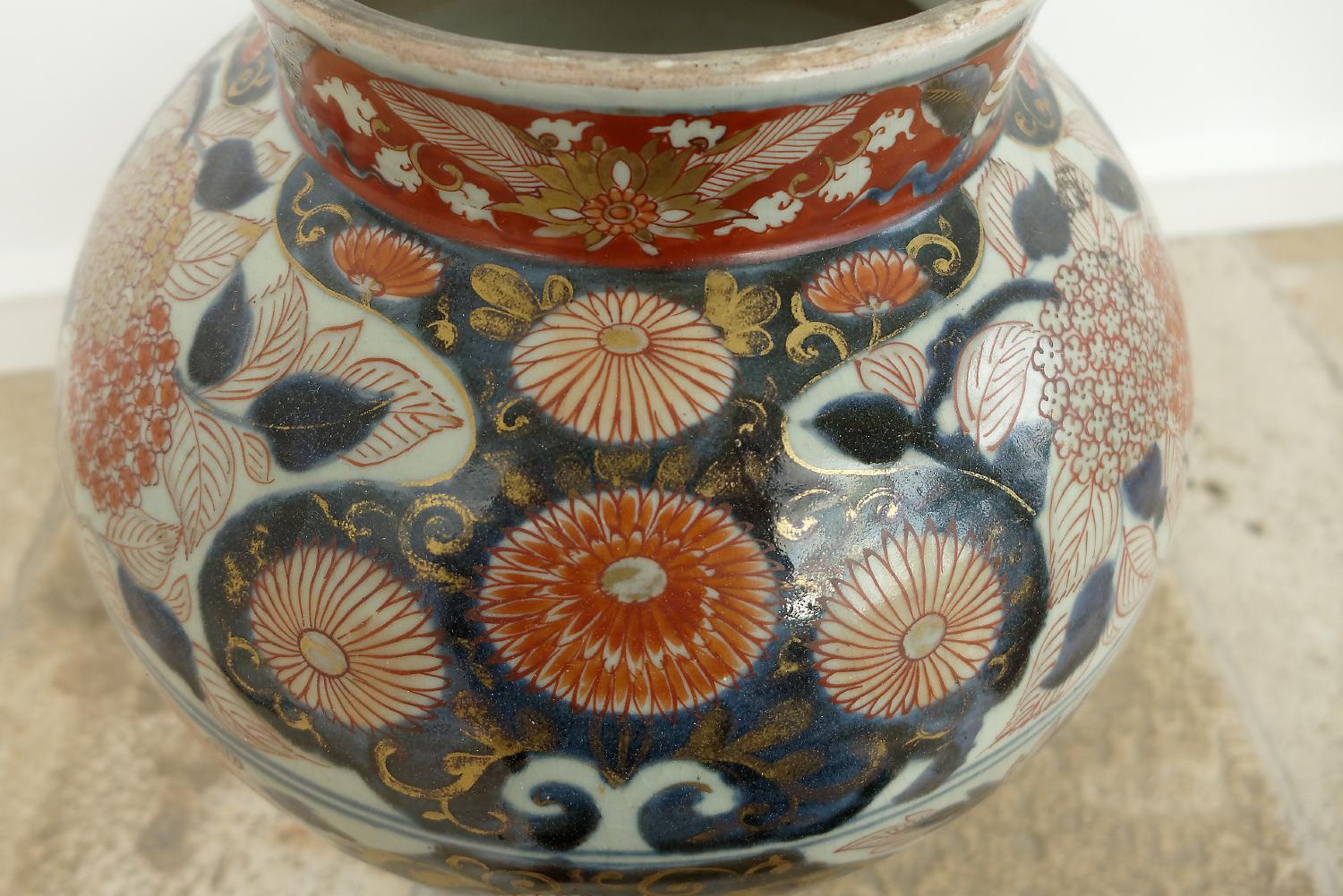 A Japanese Edo Period (late 17th century) Imari vase and cover, porcelain painted in the Imari palette of underglaze blue with overglaze iron-red and details in gold, decoration with irises, peonies and chrysanthemums, the finial in a form of