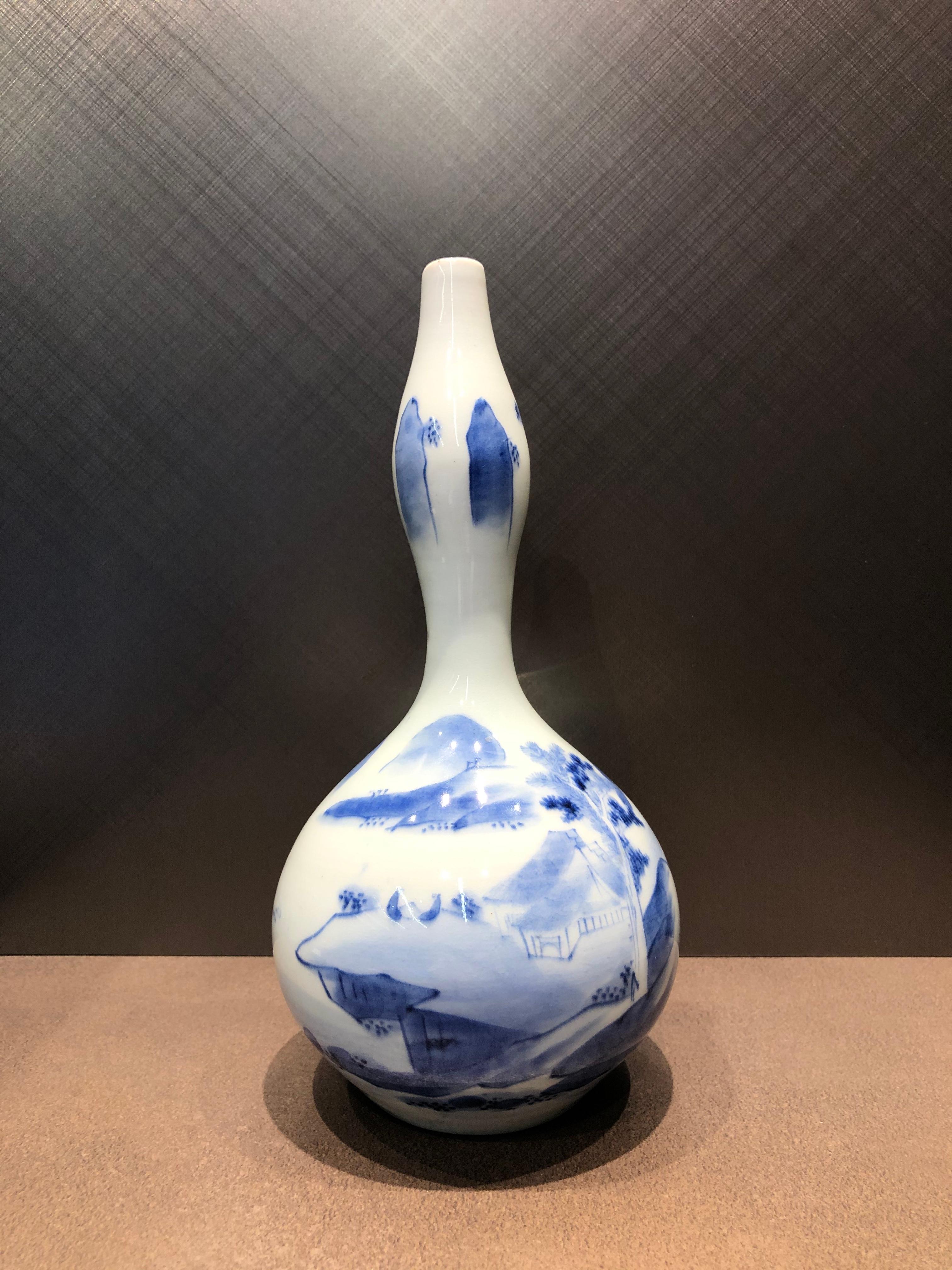 Imari ware made in the Arita area during the Edo period.

Gourd-shaped with a slender neck and mouth, it has a graceful appearance.
The style is reminiscent of Chinese Ming Dynasty paintings, with landscapes, houses, trees, and figures.