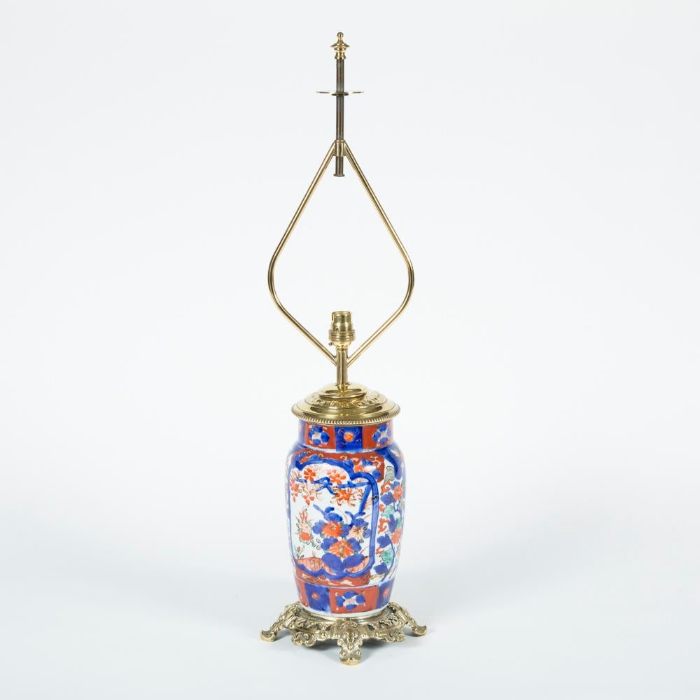 A pair of early 20th century Imari style porcelain vases converted to table lamps, with later brass mounts and fittings. 

Wired.