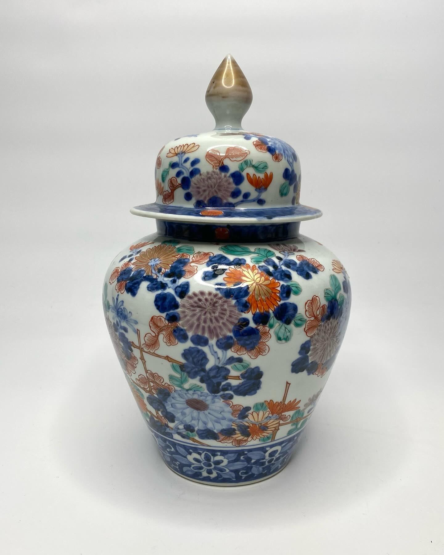 Imari porcelain vase and cover, Japan, c.1890, Meiji Period. The jar well painted with a continuous scene of flowering plants, amongst a bamboo fence, in typical Imari colours. The foot painted in underglaze blue, with a band of stylised flowering