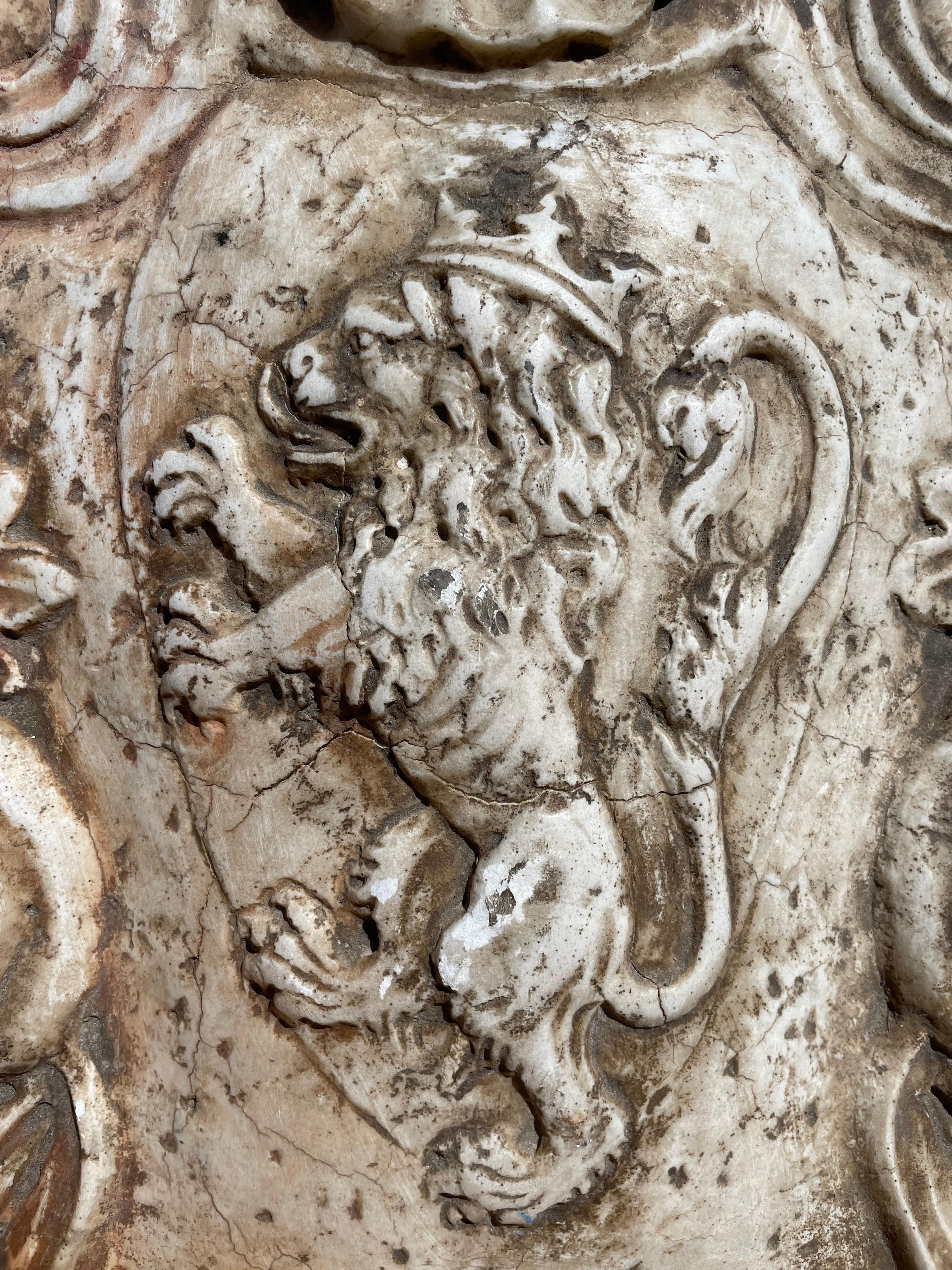 Large and finely carved lion and a crown marble statue in a very good condition with two large hooks for the wall. Weight more than 40 kg.