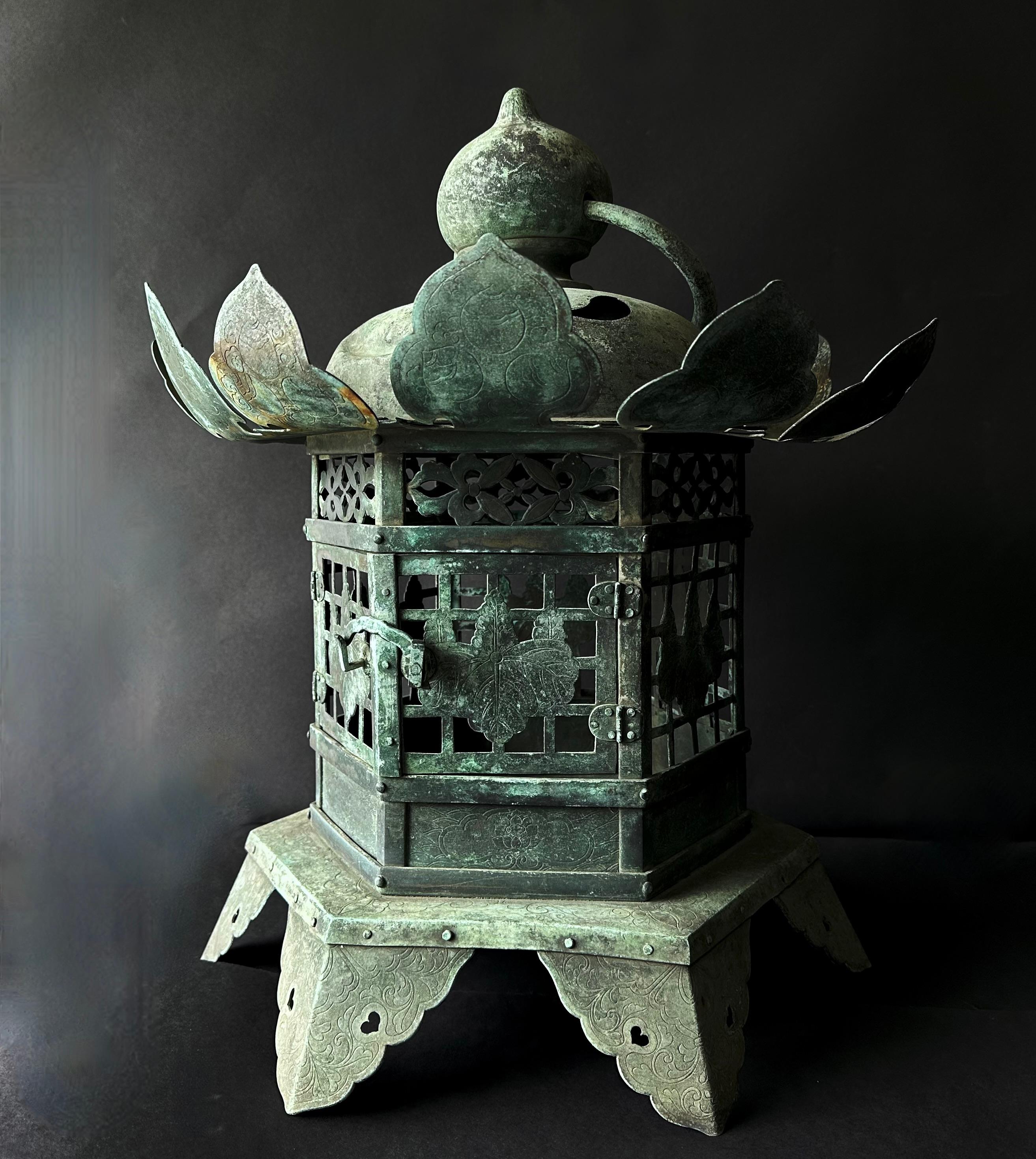 Exemplifying the grandeur of the Edo period, this substantial bronze Buddhist temple lantern is a relic steeped in both imperial provenance and spiritual significance. Circa 18th century, its surface is intricately adorned with motifs that are as