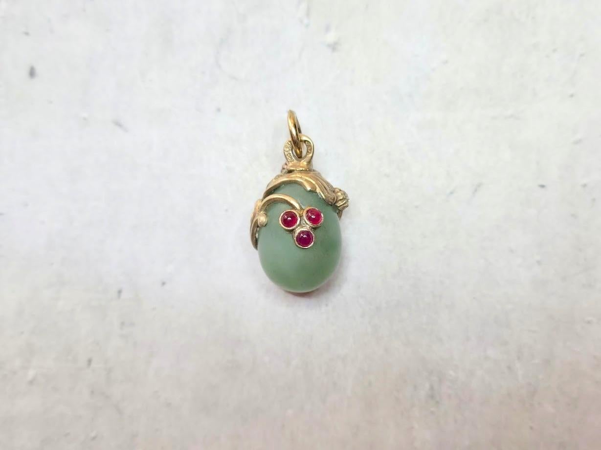 Discover a stunning gilt silver egg pendant featuring a bowenite stone, beautifully adorned with a gilded asymmetrical floral design accented by three delicate rubies and a diamond. This enchanting piece of jewelry is a true masterpiece.
What sets