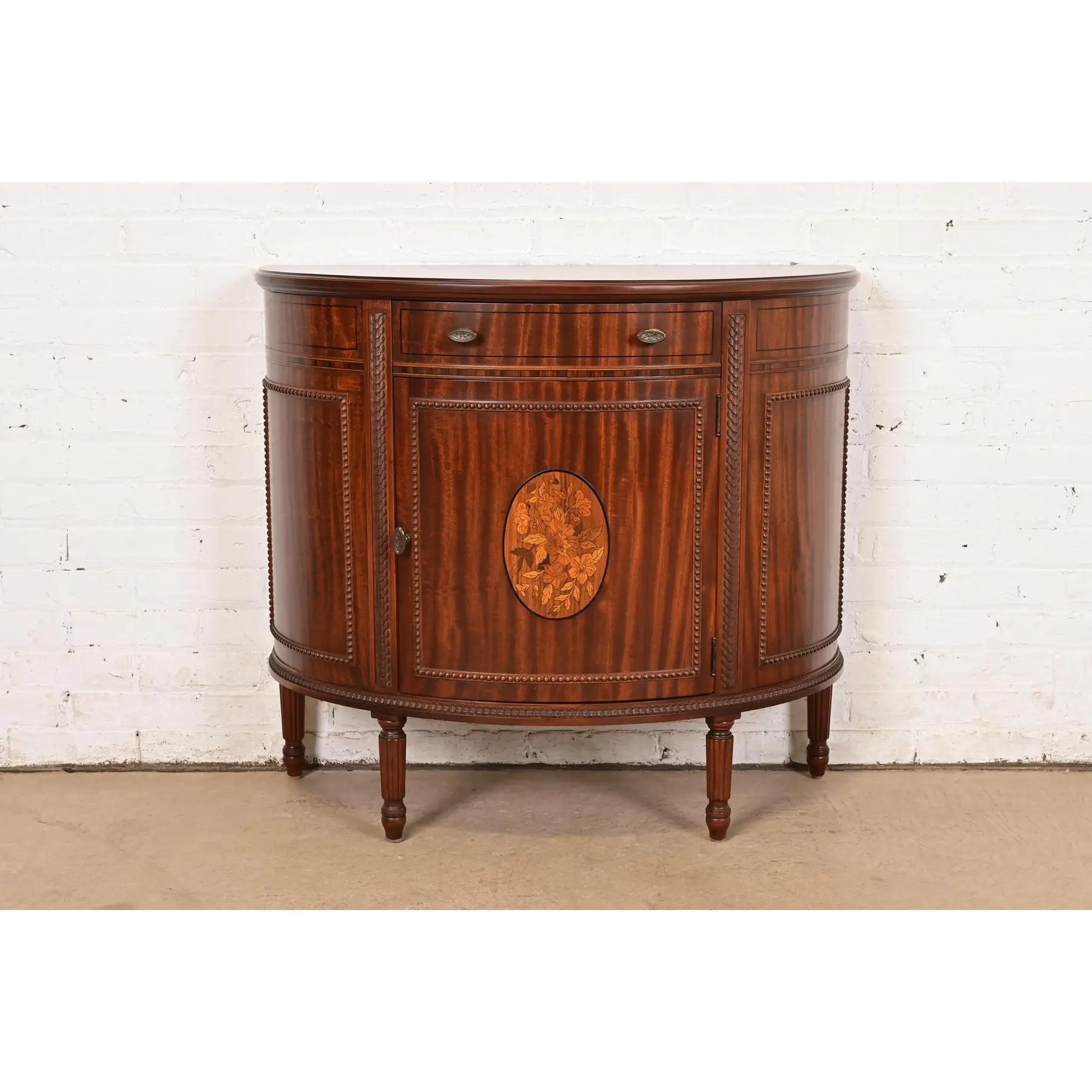 An exceptional French Regency Louis XVI style demilune cabinet or console table

By Imperial Furniture of Grand Rapids

USA, Circa 1940s

Stunning mahogany, with inlaid satinwood marquetry, and original brass hardware.

Measures: 36