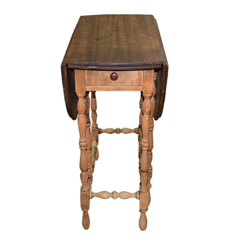 Imperial Furniture Grand Rapids wooden folding table with drawer. An elegant piece perfect for use in nearly any space. This beautiful turned-leg table features legs that fold in, which allows the folding side tops to fold. The center has a long