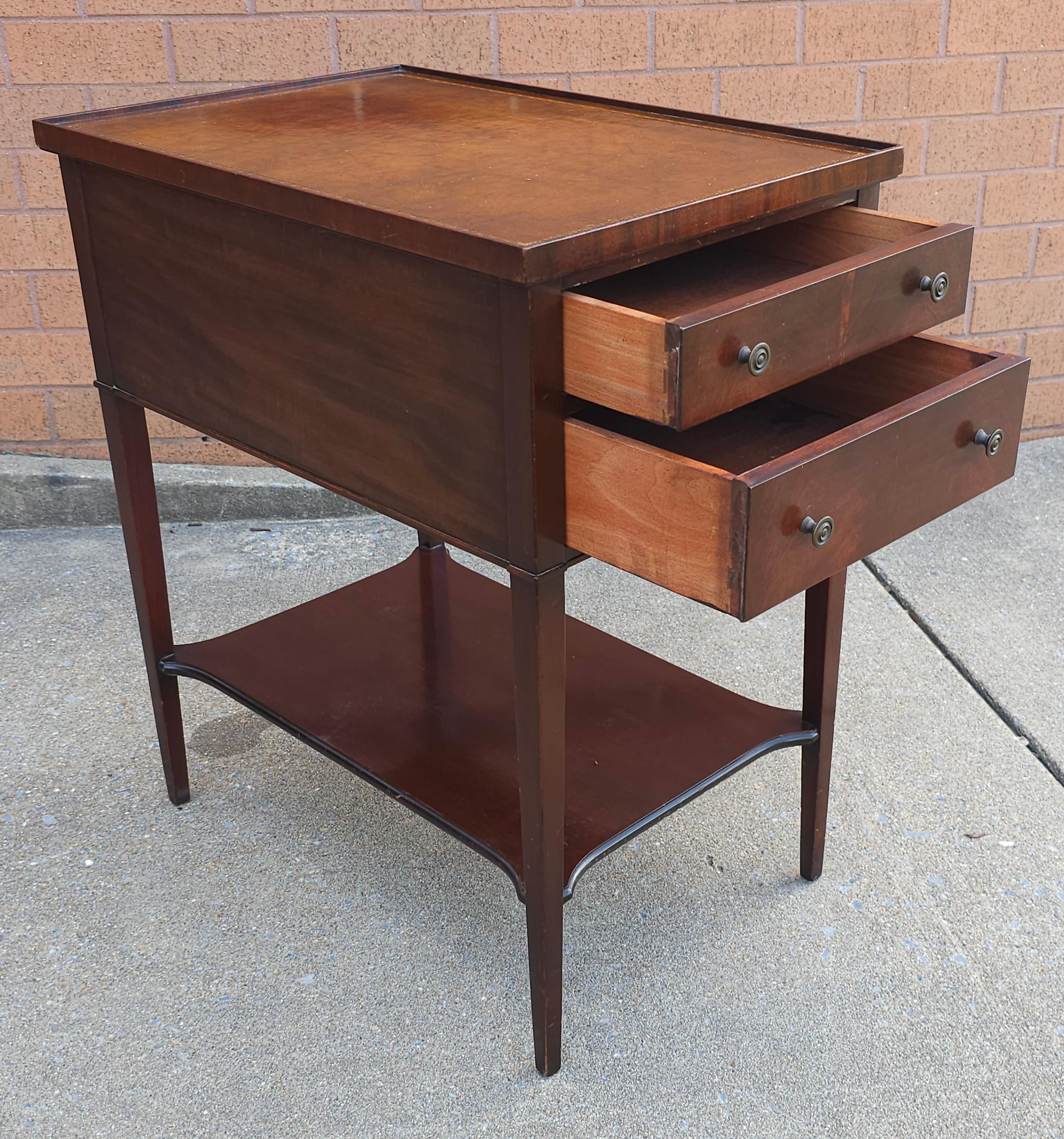 An Imperial Grand Rapids Furniture two drawer and Tooled Leather with gold stenciling Mahogany two Tiered Side Table
Measures 15