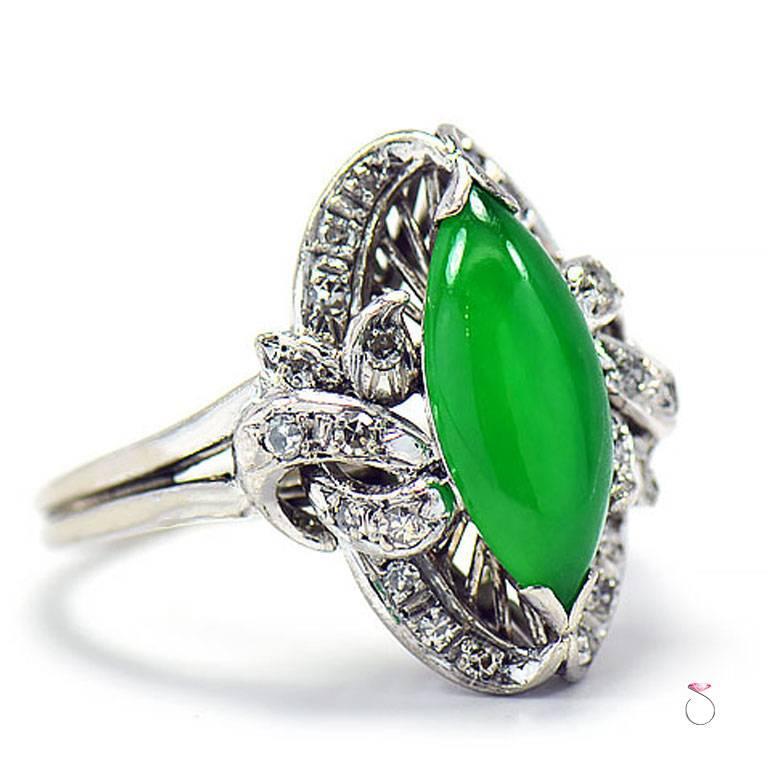 Impressive Vintage Imperial Green Jade ring from 1960's in 14K white gold with Diamonds. The gorgeous center stone is a GIA certified natural green Jadeite jade, Cabochon Marquise shape surrounded by a beautiful halo with scroll design on the sides