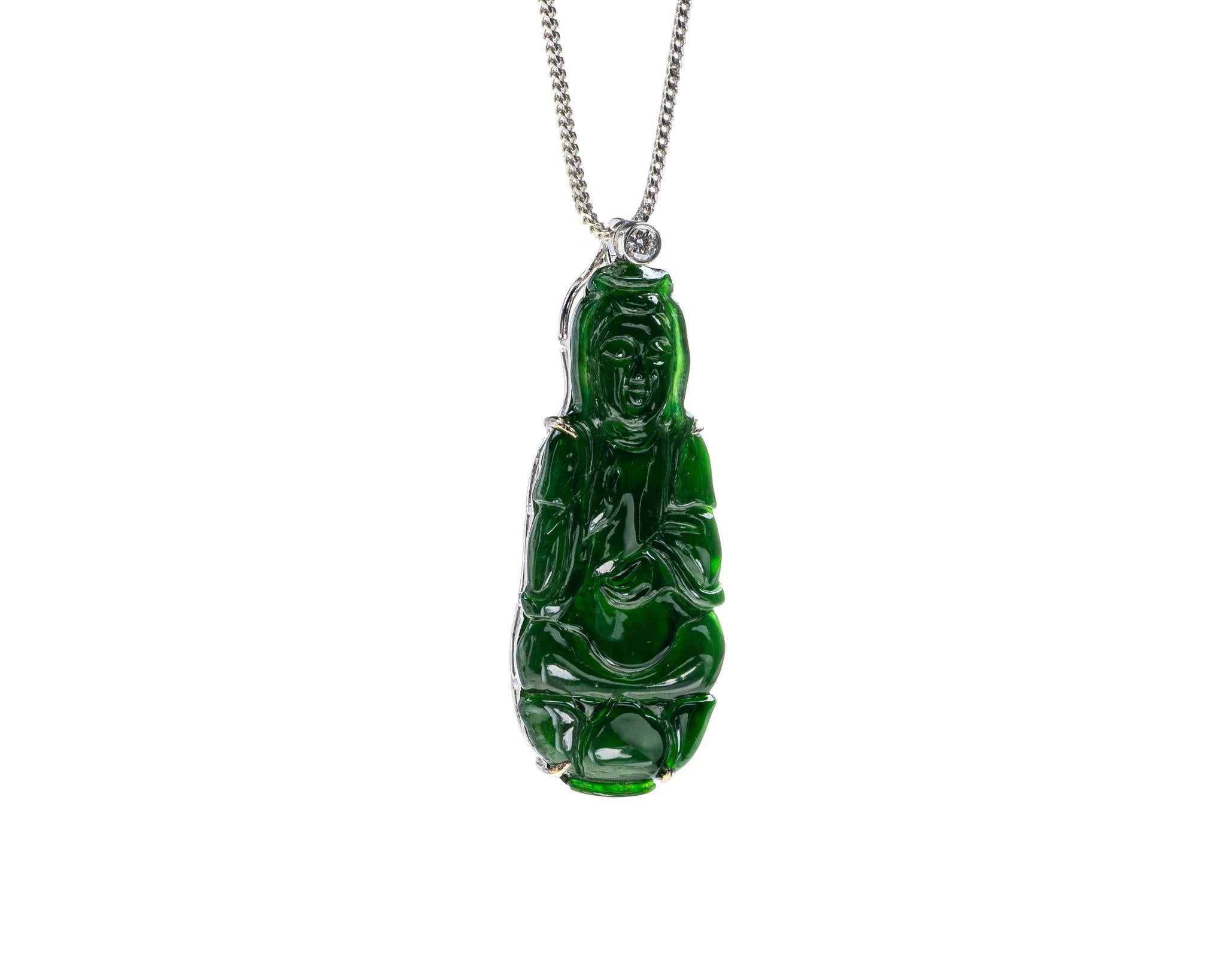 This is an all natural, untreated green jadeite jade carved Quan Yin god pendant set on an 18K white gold bail.  The carved Quan Yin god symbolizes compassion and protection. 

It measures 0.61  inches (15.7 mm) x 1.55 inches (39.5 mm) with