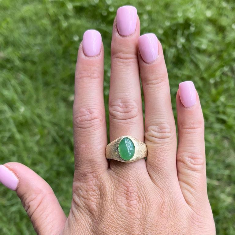 Oval shape cabochon imperial green jadeite jade ring, bezel set in 14k yellow gold. The Jade measures approximately 13.94 mm x 10.29 mm x 5.12 mm with an estimated weight of 6.62 carats. The ring has a rounded tapered shank with a brushed finish all