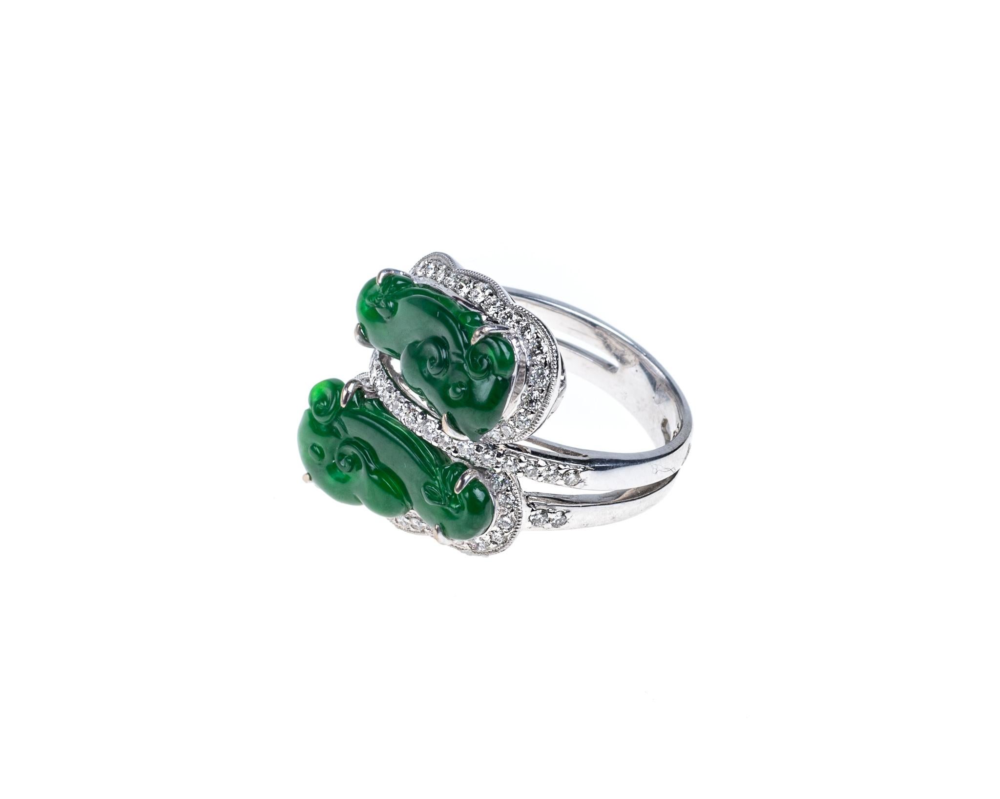 This all natural, untreated imperial green jadeite jade and diamond ring has two pieces of fine imperial jadeite jade in carved into two ruyi clouds that symbolizes power and good fortune.  
It measures 0.72 inches (18.4mm) x 0.77 inches (6mm) and