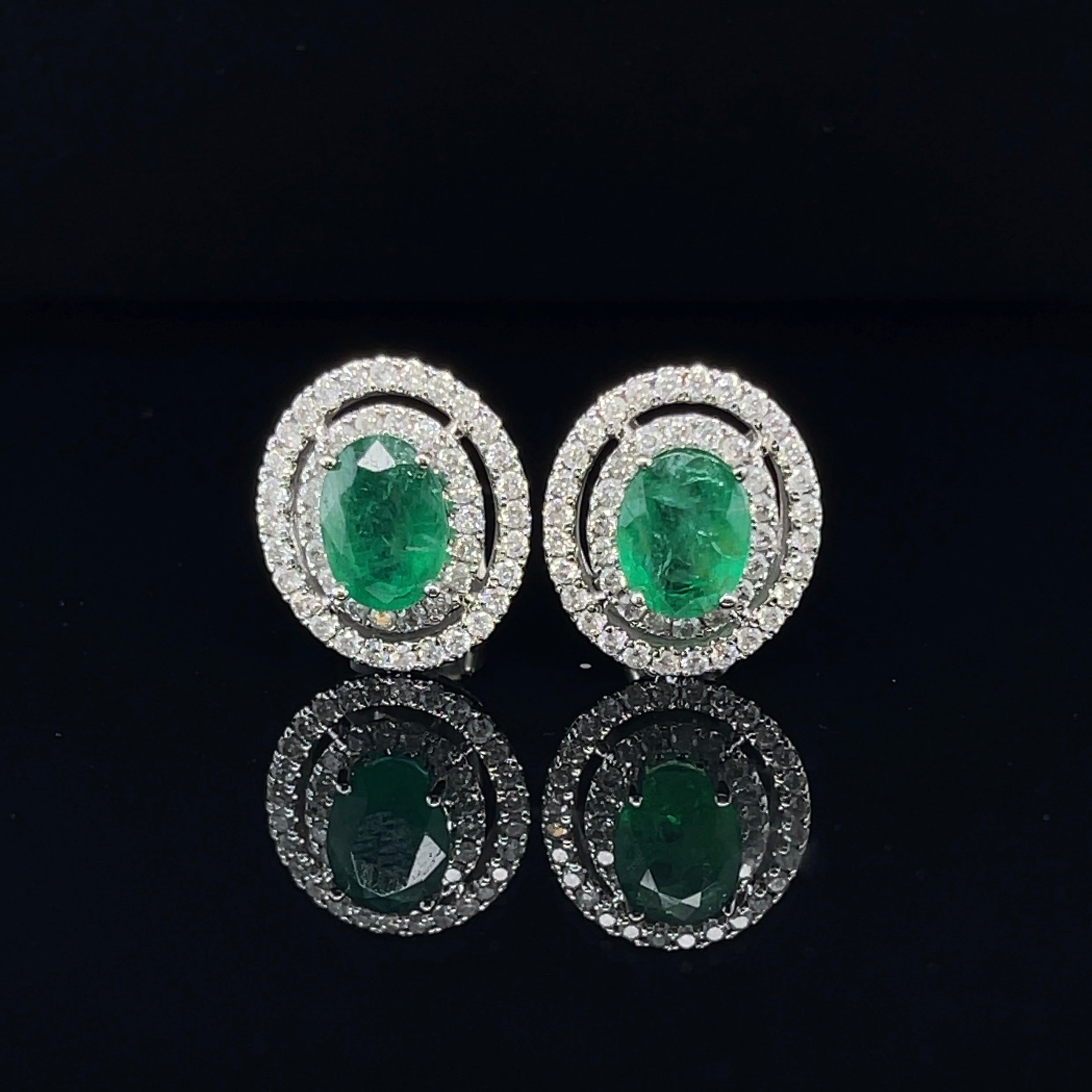 Oval shaped natural emeralds stud earrings, crafted in Eighteen Karat white gold, featuring claw set natural round brilliant cut diamonds, complemented with a stunning polish finish. 

Total Emerald Weight: 2.17ct 
Emerald Colour/Grade: 