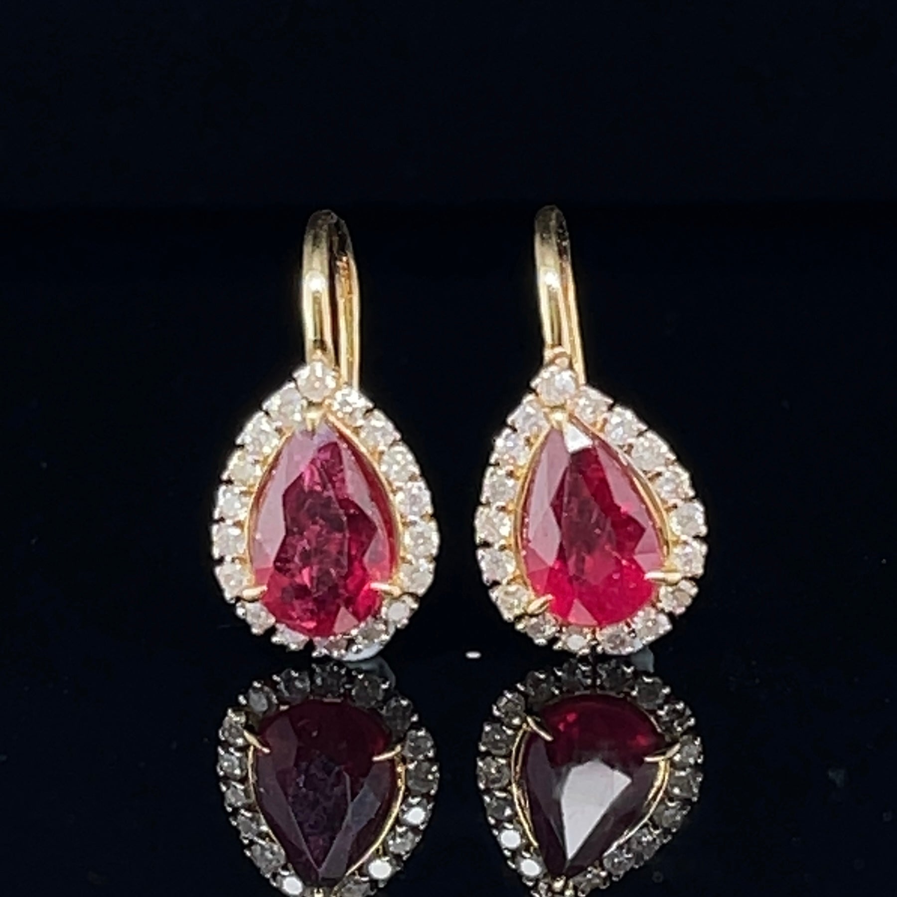 A classic, Pear Cut Natural Rubies, accompanied by a beautiful set of round Brilliant cut diamonds on an eighteen karat shepherds hook designed earrings. 

Ruby Weight : 2.08ct
Ruby Colour: 