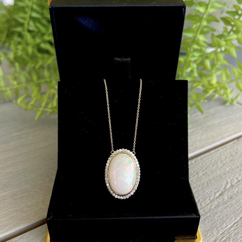 Oval natural semi-crystal opal cabochon, crafted with Eighteen Karat Yellow Gold, featuring forty eight claw set natural round brilliant cut diamonds, complemented by a beautifully polished finish.

Opal Weight: 7.09ct
Opal Colour: Orange and Green