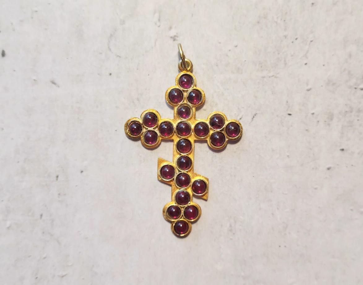 We present an Imperial Russian gilt silver Orthodox cross pendant with 22 cabochon cut garnet gemstones throughout the front side. The cross is made of 88 imperial silver and encrusted with garnet gemstones. It is truly a unique piece of