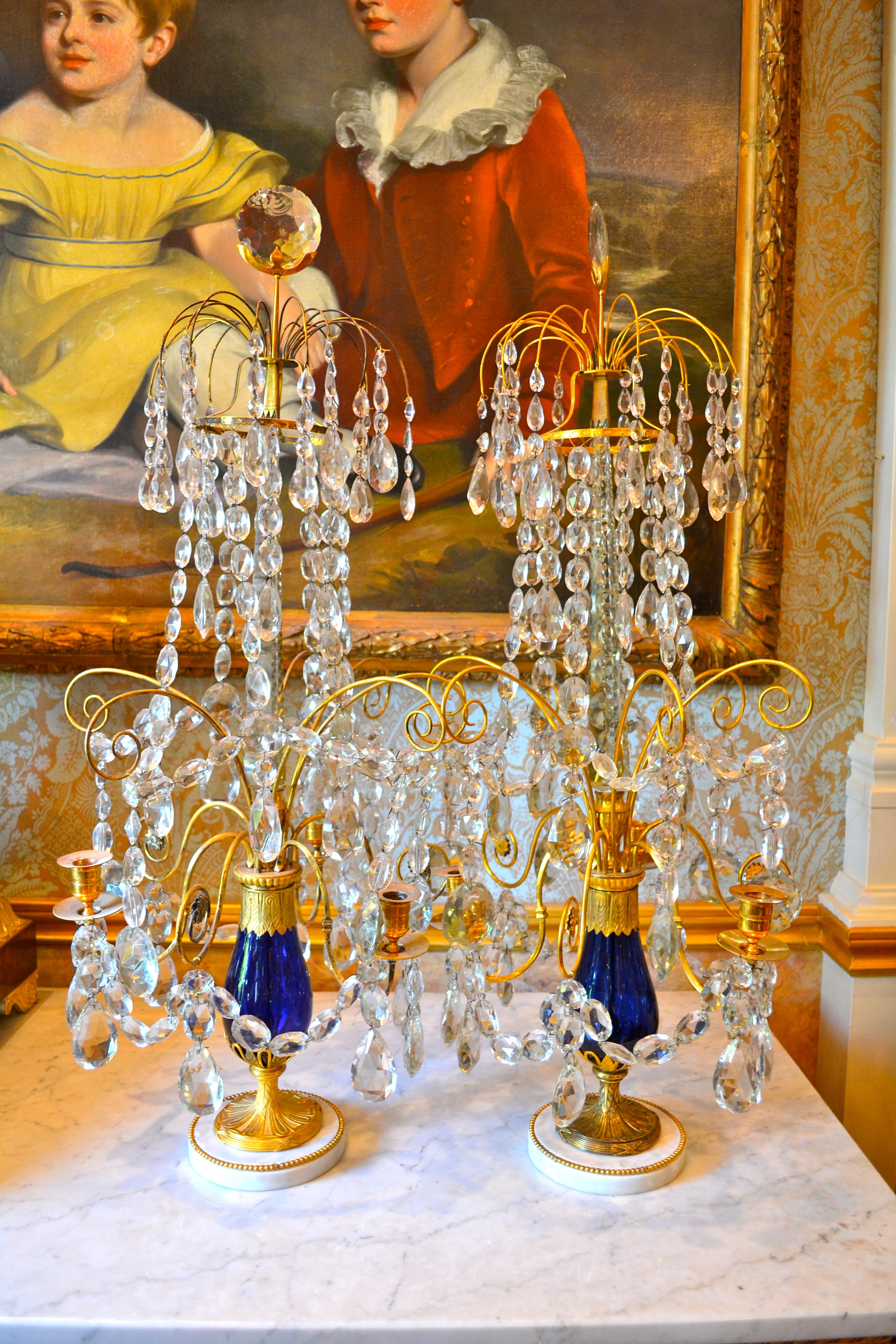 Ein Paar sehr seltener exquisiter kaiserlich-russischer Kristallgirandolen, jede mit fünf verschlungenen Kerzenzweigen in einer kobaltblauen Glasbalustervase, montiert in vergoldeter Bronze, der zentrale facettierte Obelisk trägt originale Kristalle