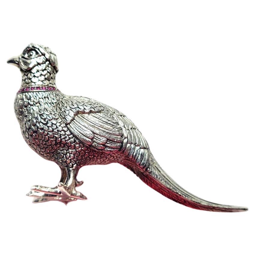 This is an exceedingly rare Imperial Russian silver figurine, a true gem for collectors. It is meticulously modeled as a pheasant adorned with a ruby collar. The pheasant is cast and chased with remarkable realism, and the ruby gemstones add a touch