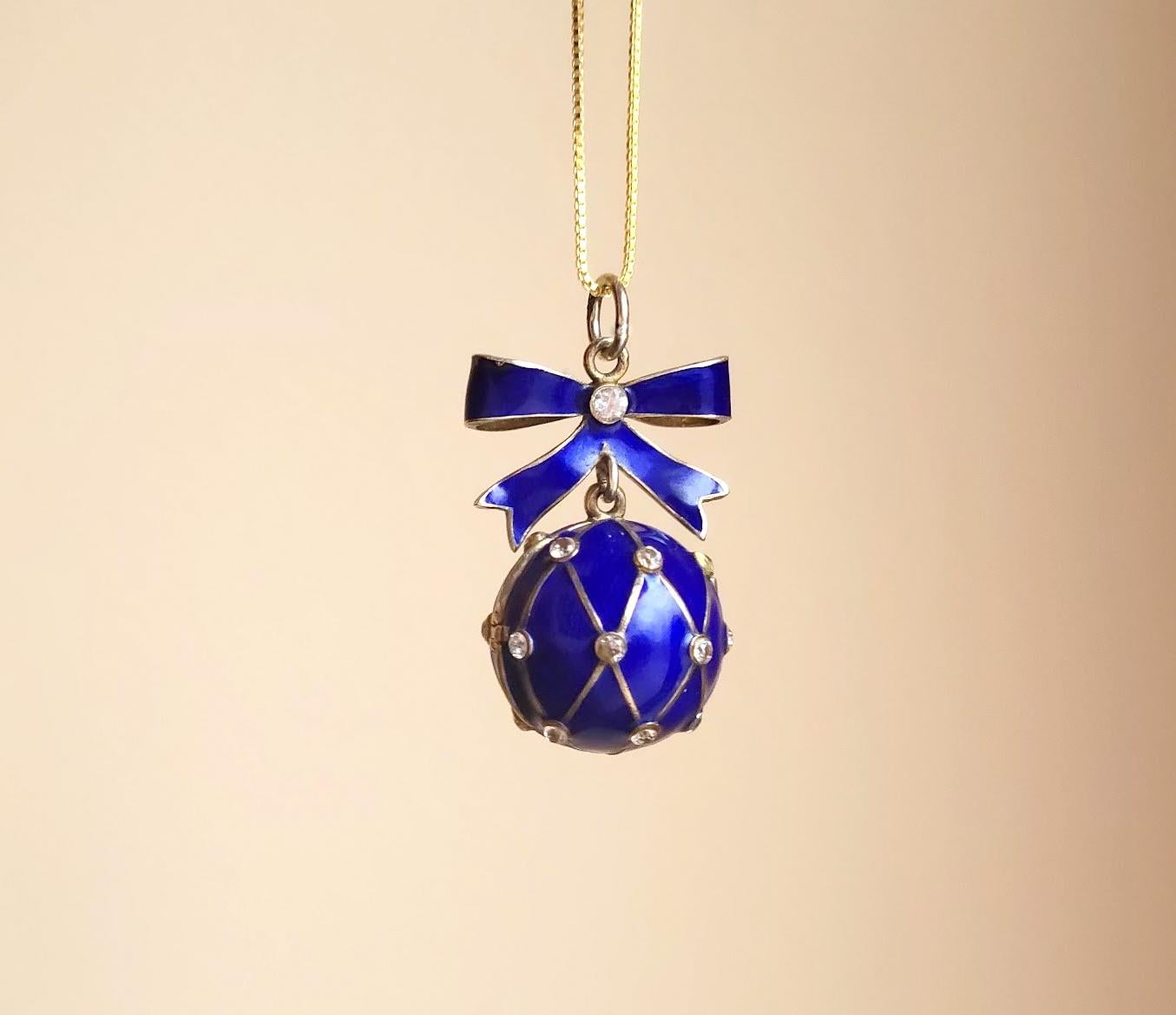Presenting a stunning pendant designed in the shape of a Russian Imperial 88 gilt silver and enamel egg. This exquisite piece showcases a relief image of the cobalt mesh with a diamond simulant* adorned with gold and blue enamel. The loop on the
