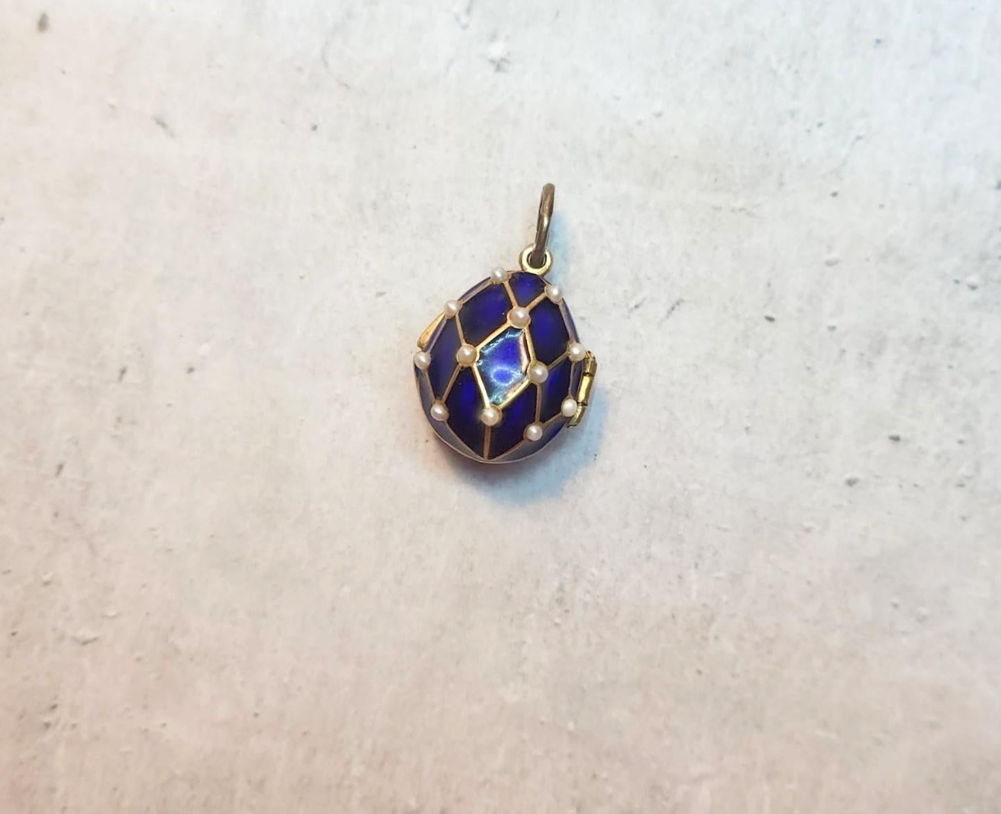 Presenting a stunning pendant designed in the shape of a Russian Imperial 88 gilt silver and enamel egg. This exquisite piece showcases a relief image of the cobalt mesh with natural pearls adorned with gold and Guilloche blue enamel. The loop on