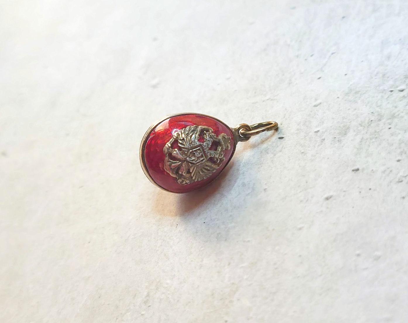 Ti presentiamo uno splendido ciondolo a forma di uovo imperiale russo in argento dorato e smalto arabescato. Il corpo dell'uovo è smaltato con un bellissimo smalto guilloché rosso intenso. I motivi ripetuti dello smalto sembrano centinaia di raggi