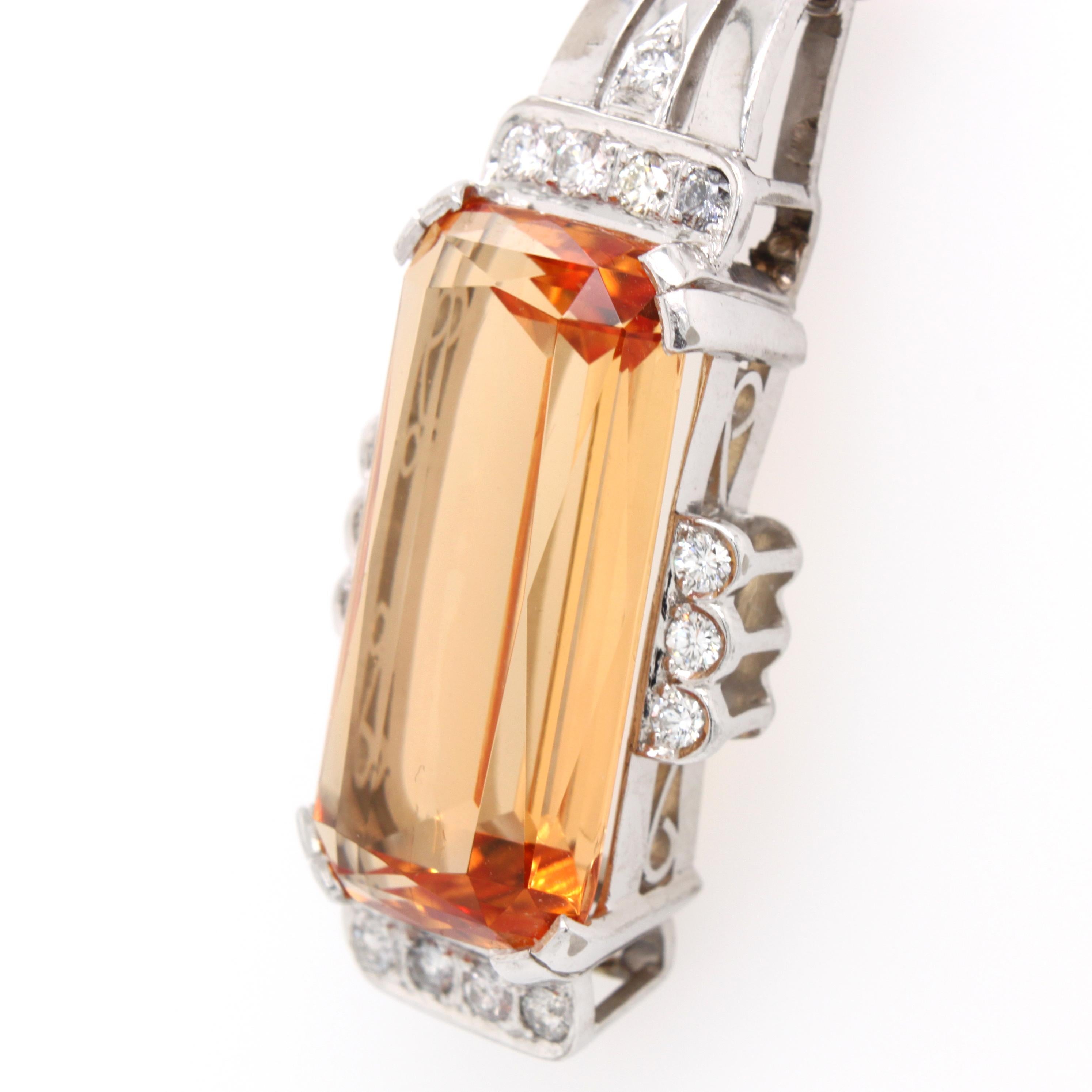 An imperial topaz and diamond pendant in 18k white gold. The imperial topaz has a beautiful golden sherry colour with peachy orange hues. It is absolutely free of visible inclusions and weighs approximately 17 carats. The gemstone has a very