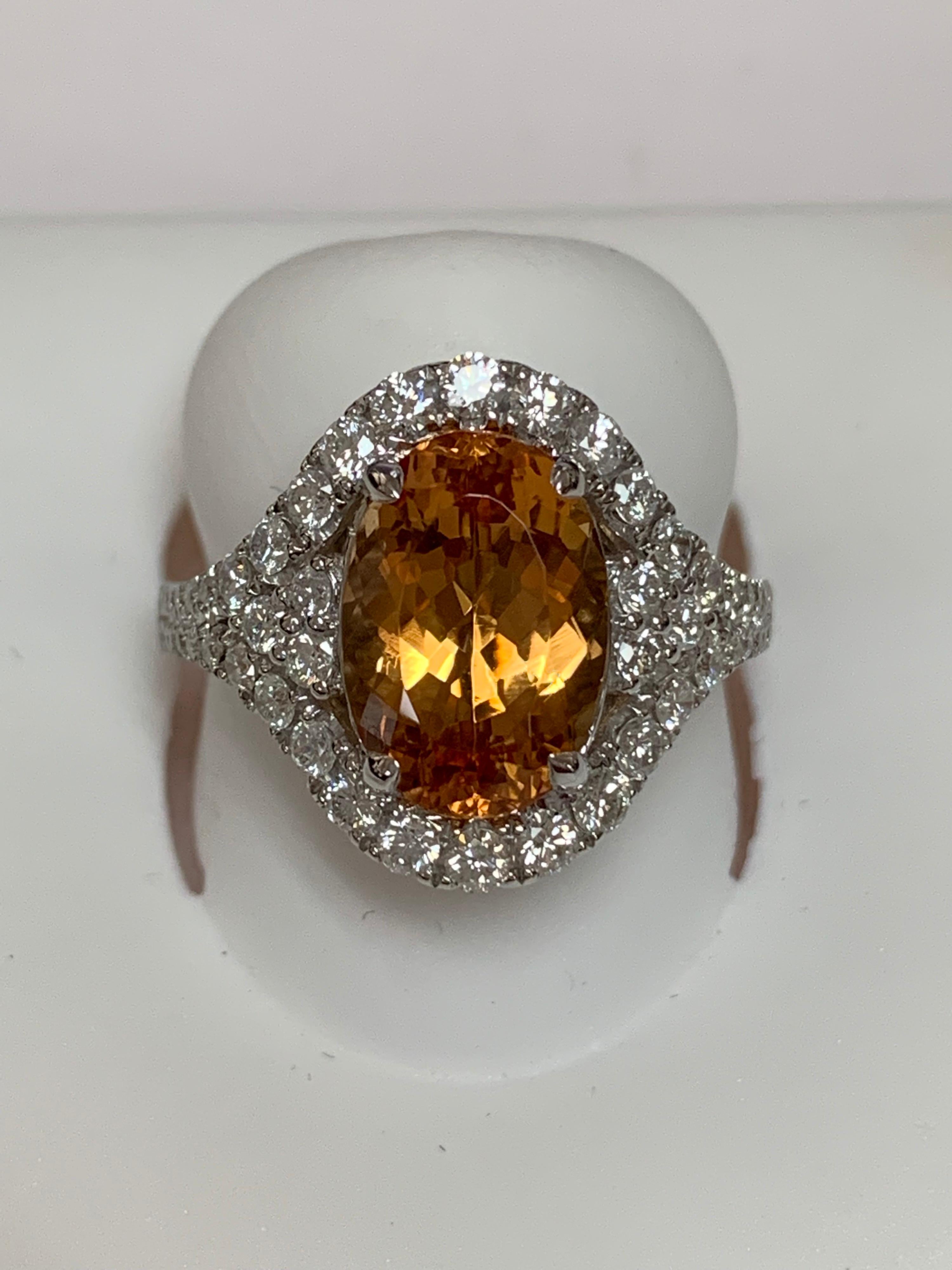 Oval imperial topaz 4.02 Carat and 0.84 Carat round white diamonds set in a 14 Karat is a one of  a kind hand crafted ring. The ring is size 7 but can be resized if needed.