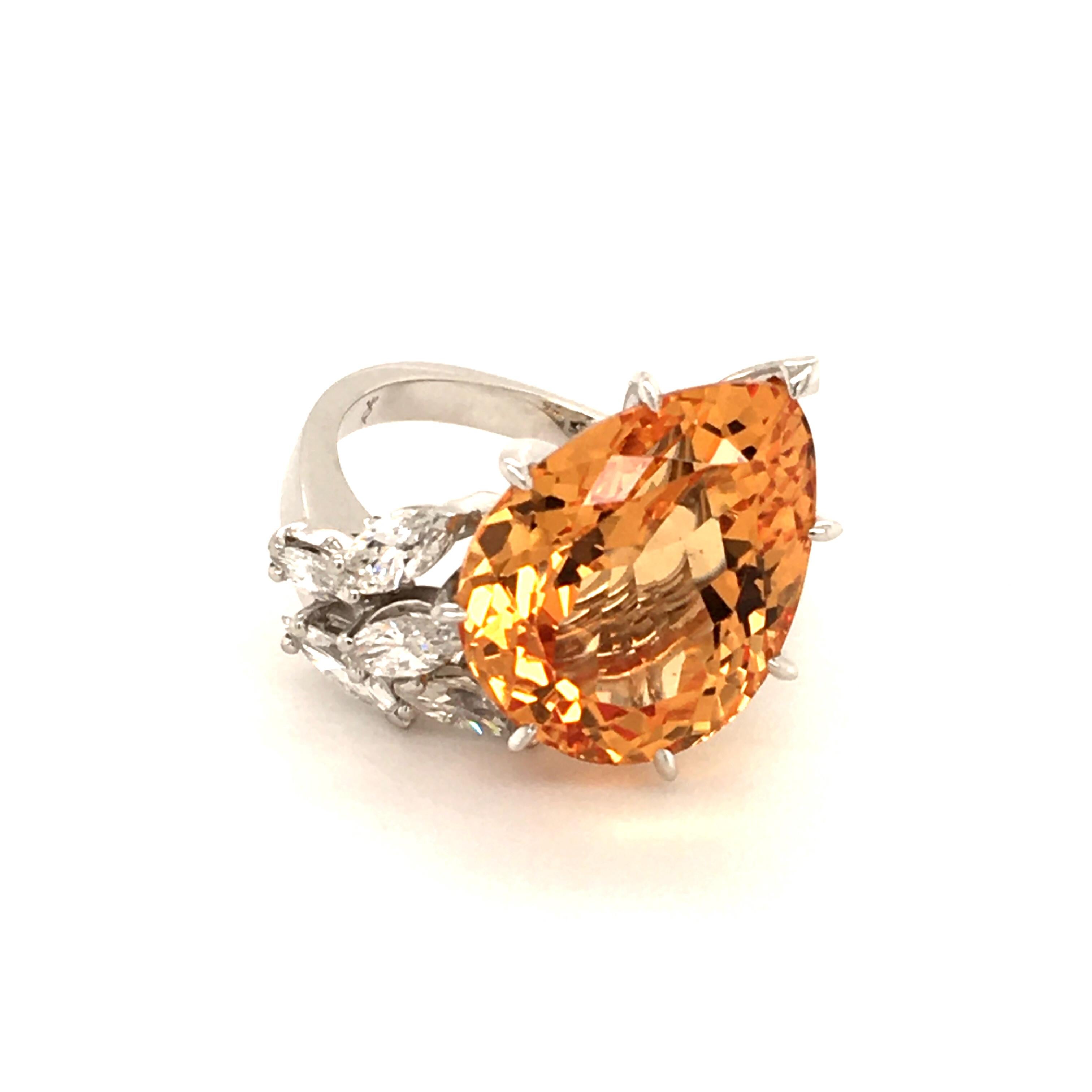 Amazing ring in white gold 750, prong set with following gemstones:

1  beautiful clean imperial topaz of yellowish orange colour, pearshape, approx. 11 ct
5 marquise cut diamonds totaling approx. 0.60 ct of G/H-vs quality

Ring size: 54 (EU) / 7
