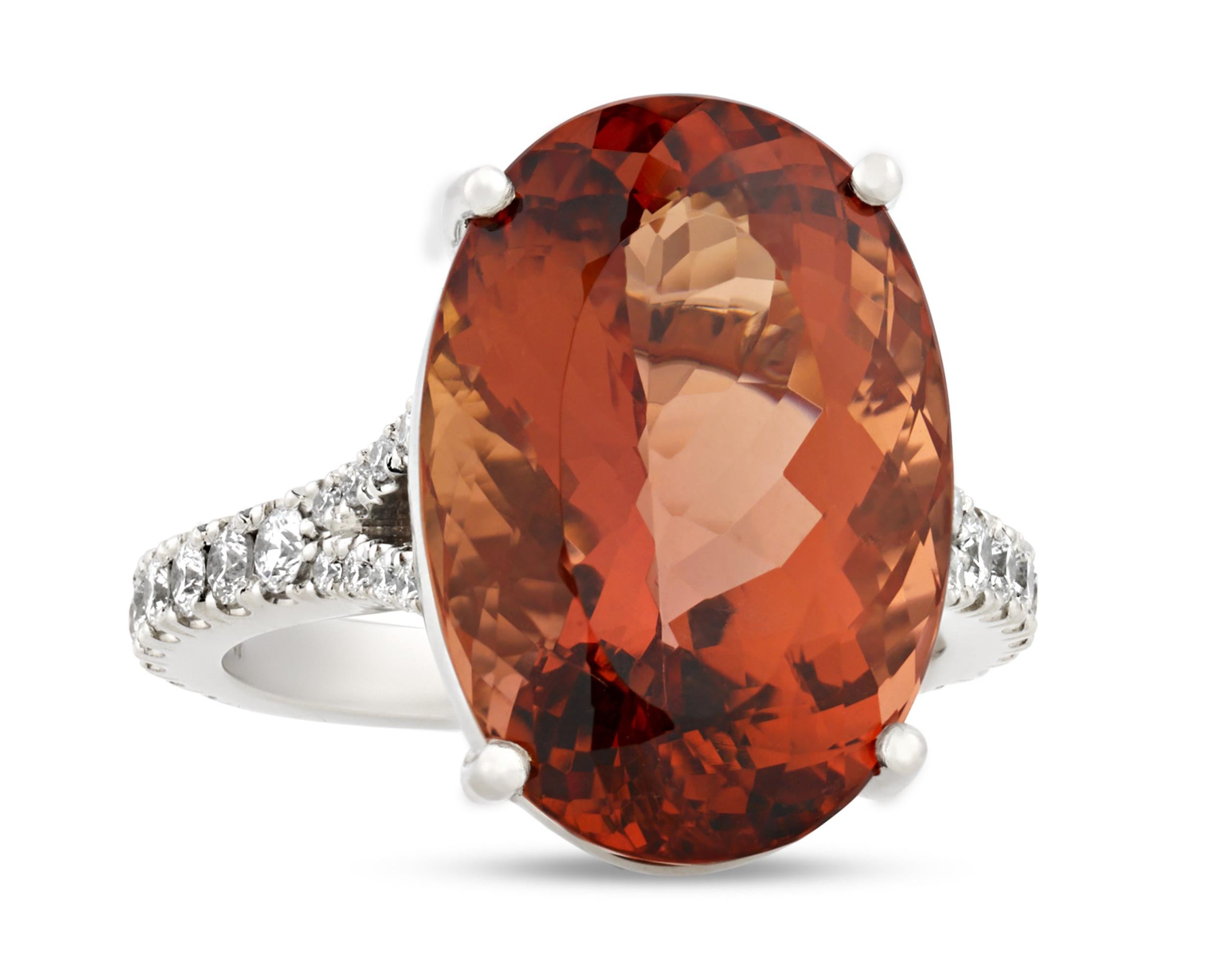 An imperial topaz weighing a monumental 15.61 carats and displaying a highly prized reddish-orange hue is the star of this remarkable ring. Imperial topaz is the rarest of all topaz varieties, and this stone is certified by the American Gemological