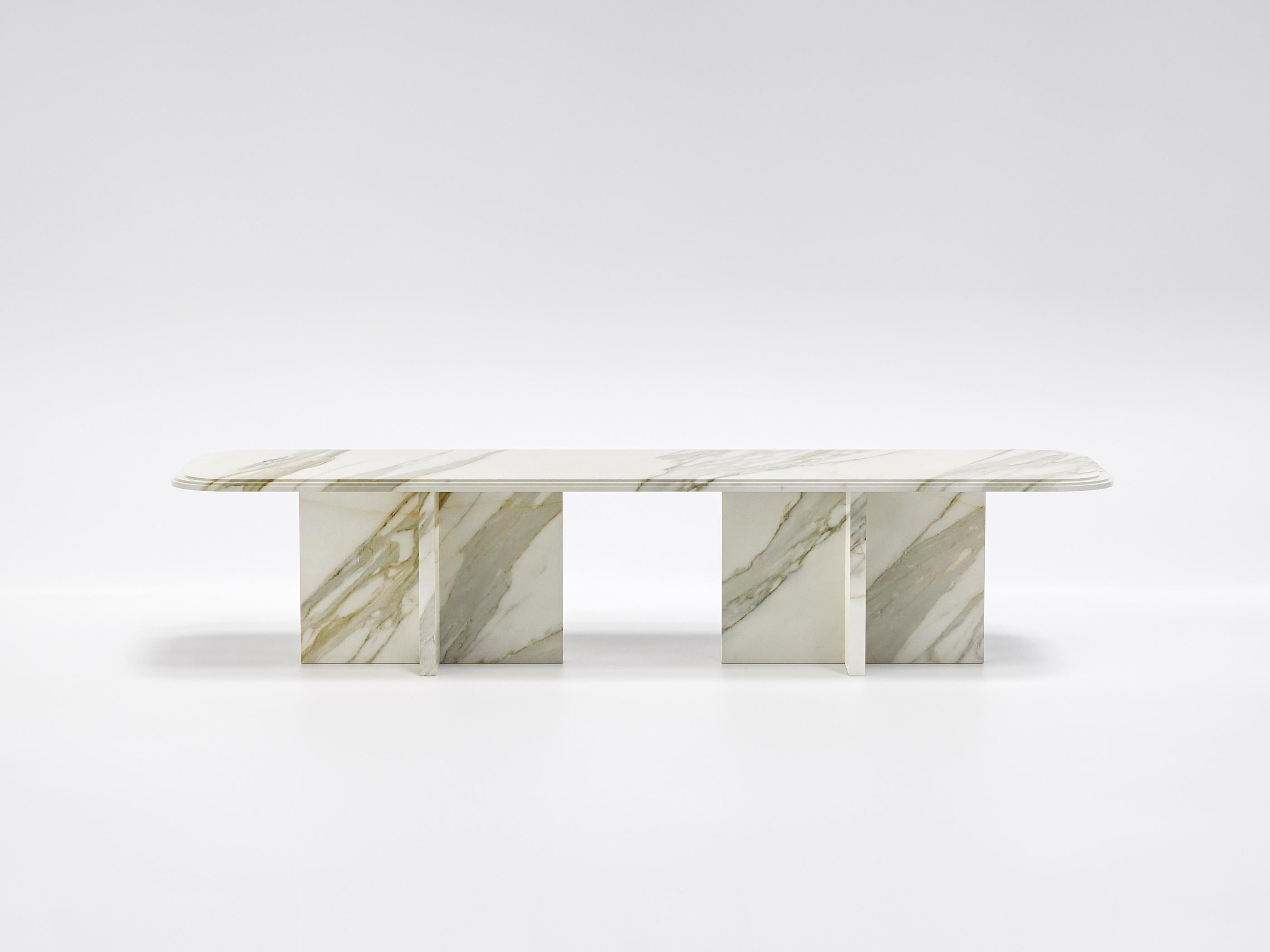Imperium est une table-sculpture qui incarne la force, l'équilibre et l'élégance intemporelle.
Entièrement réalisée en marbre Calacatta Gold, sélectionné pour ses veines dorées et gris perle sur fond ivoire, cette table domine l'espace par sa