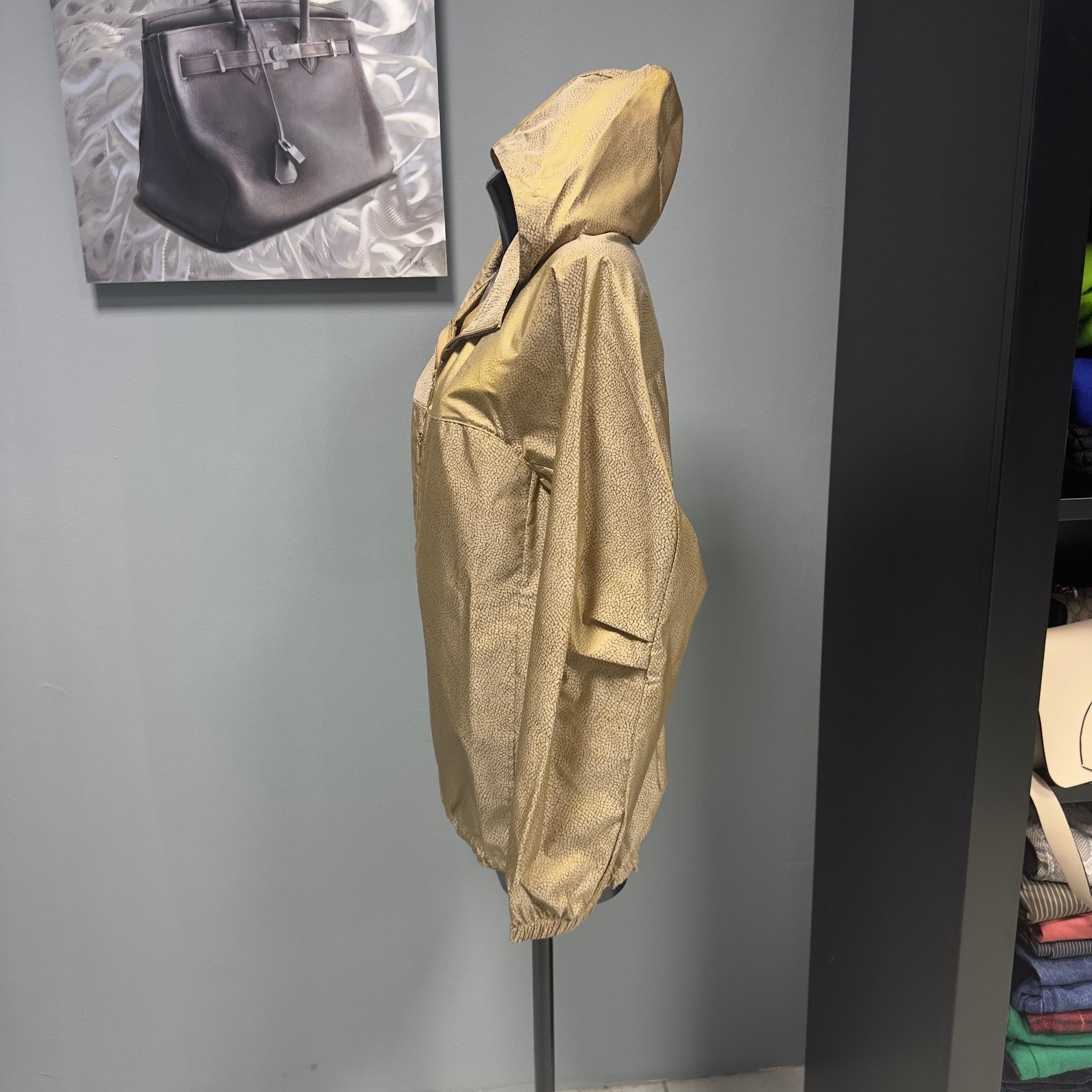 Giacca a vento, impermeabile Borbonese con trama tipica del brand leggermente cangiante 
Chiusura con zip, tasche laterali e capuccio 
Aperture sotto ascella e coulisse sul fondo regolabile 
Condizioni ottime 
Misure : 
Spalle 44cm
Manica 65cm
Petto