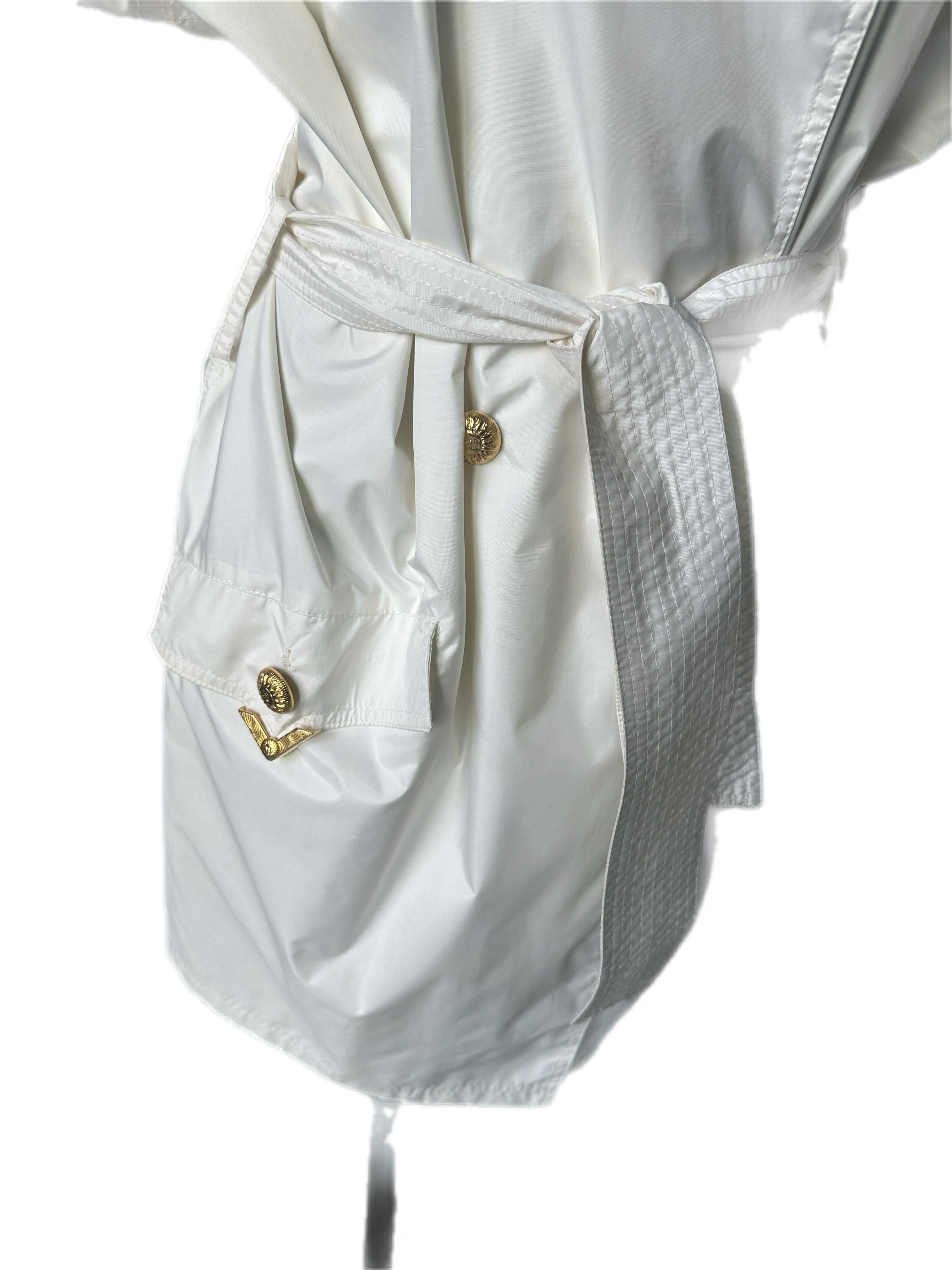 White raincoat Versace Sport
Raglan sleeve, double-breasted button placket overlay for wind protection, slant pockets, flap at top back, wrist straps
All featuring gold logoed buttons and finish metalwork
The item was used so it needs to be washed,