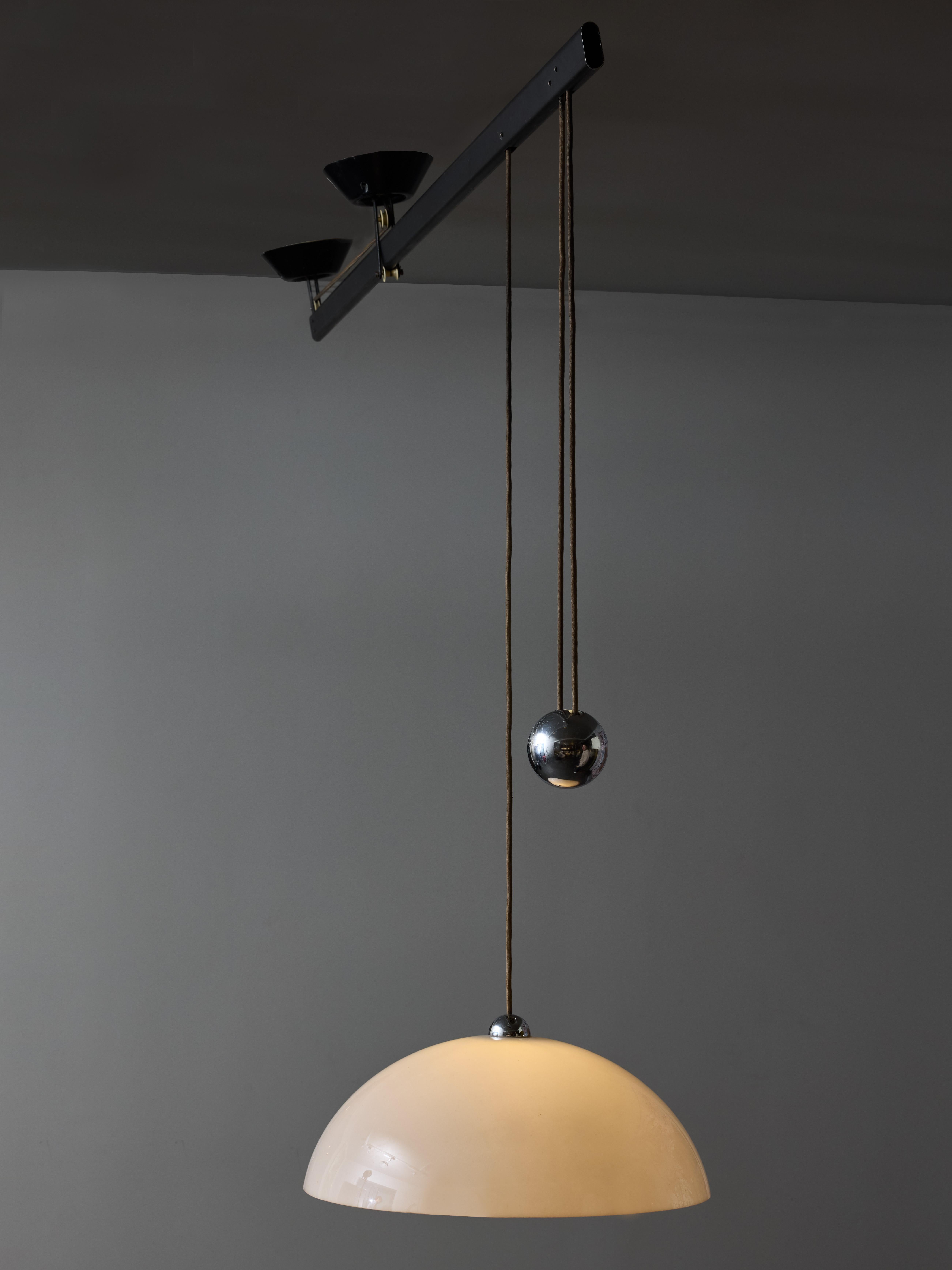 Impiccato chandelier designed by Vico Magistretti for Artemide, circa 1960s.

This piece based on balance has only one fixed ceiling plate (left on the pictures) attached to a metal oval tube. The other one slides along the tube thanks to pulleys.
