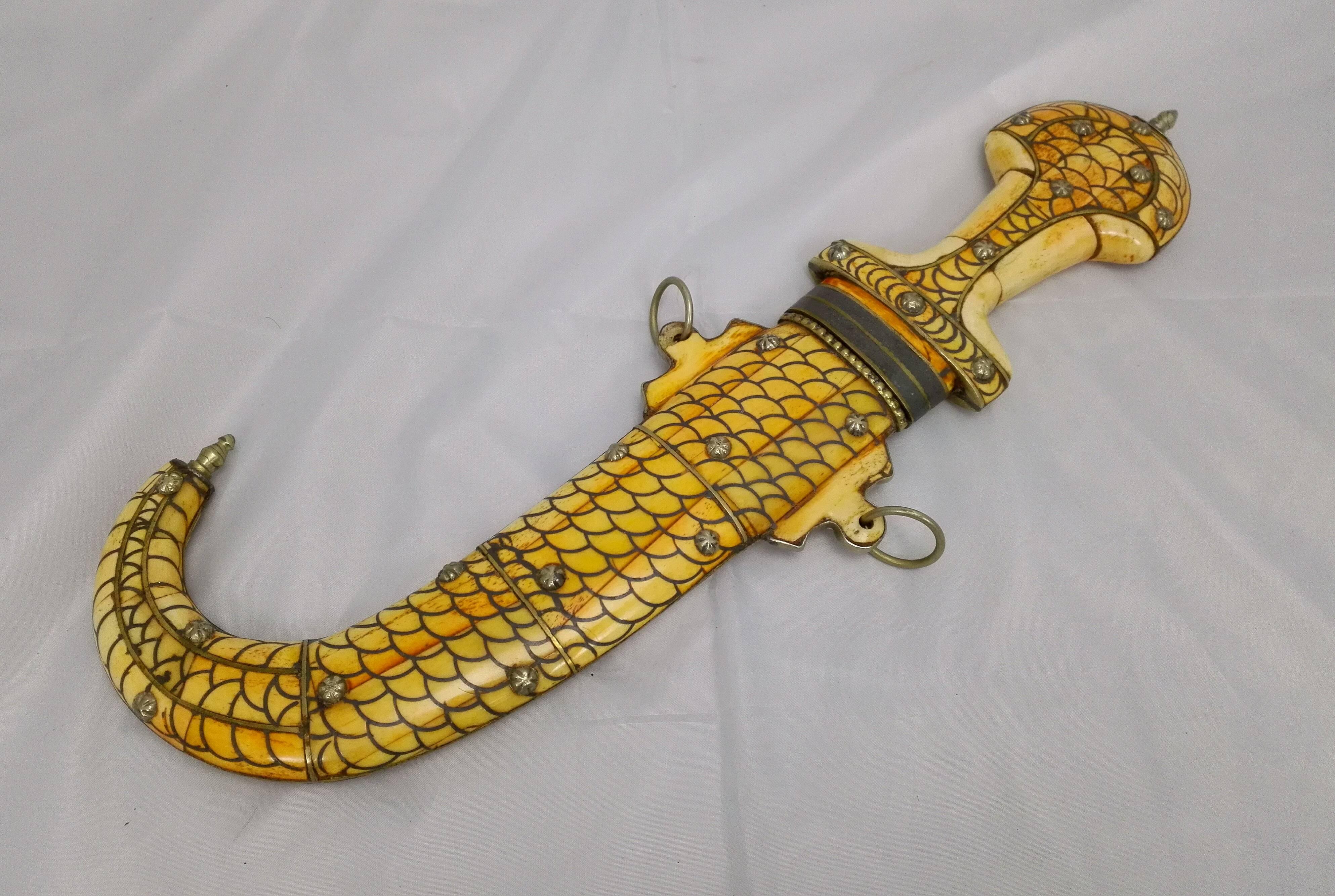 This unique dagger from the 18th century and earlier, is just a dream! The handle and the scabbart are laid up with leg in scale armor still with decorated bronze rivets. In my opinion more beautiful as that of Laurence from Arabia! And for this age