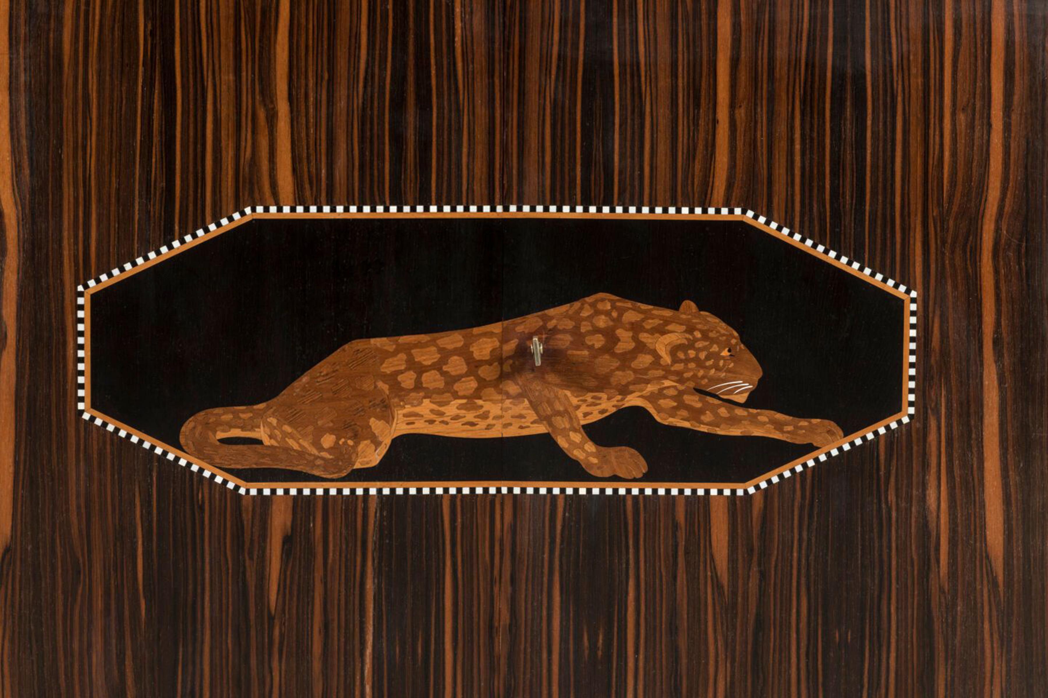 Important 1925 Art Deco Macassar Ebony Inlaid Sideboard by Christian Krass.

Decorated with an extraordinary inlaid marquetry of a reclining leopard within a black, elongated octagonal frame bordered with white squares . And two side panels