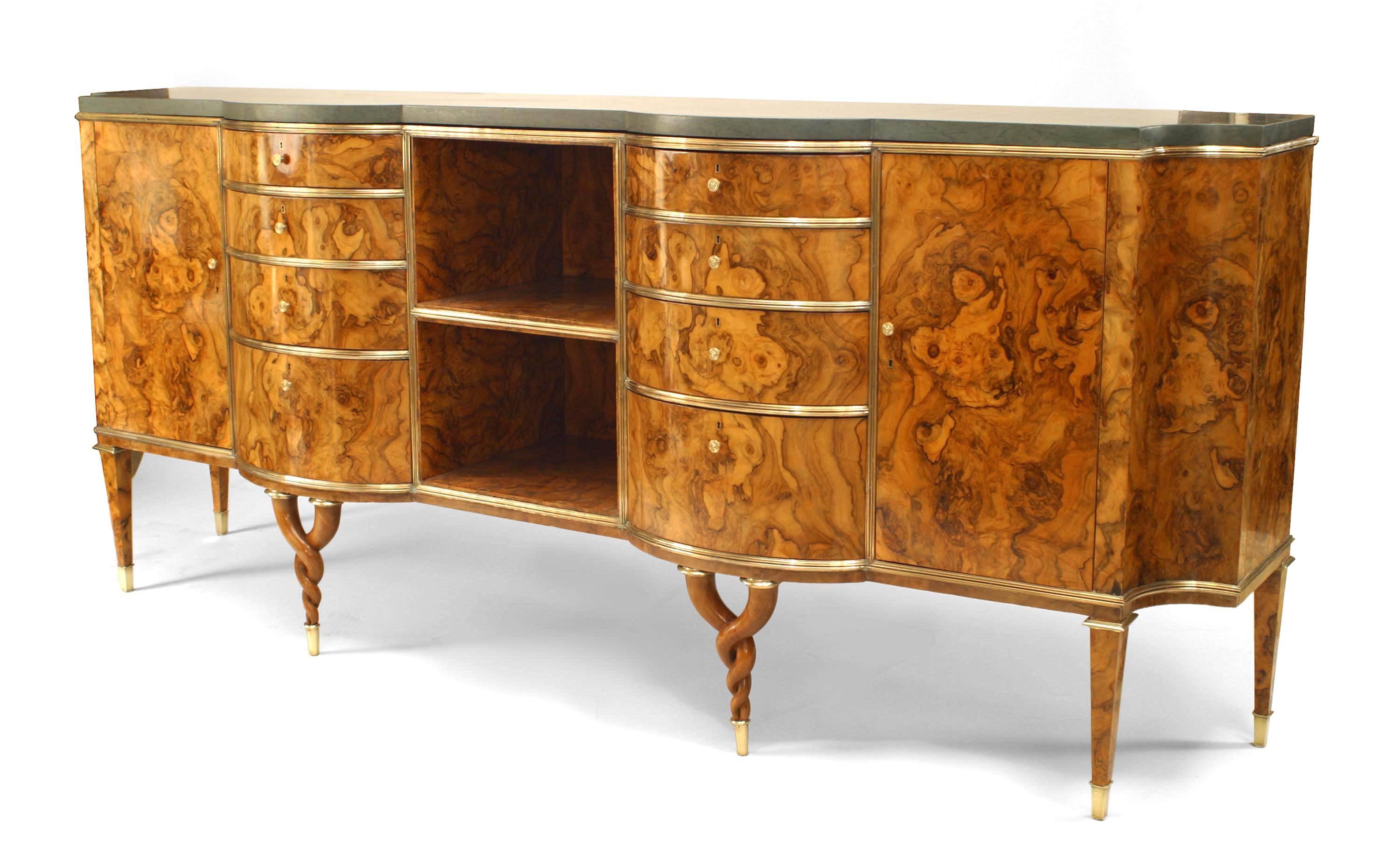 Attributed to Tomaso Buzzi, 1940s, Italian burl root veneered sideboard with twisted legs, a green marble top, and bronze trim. The piece features two stacked open shelves flanked by two sets of four drawers, and two cabinet doors.


Born in