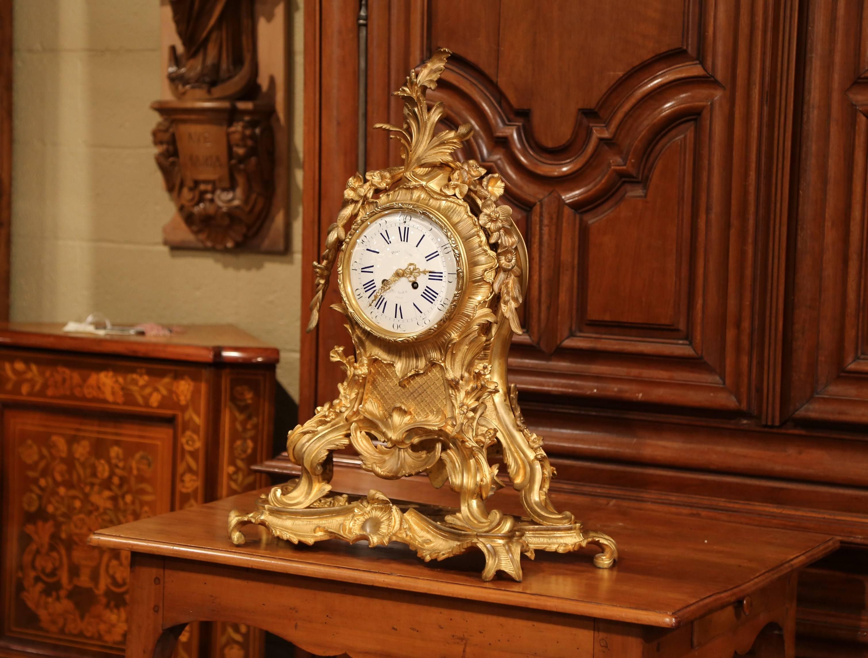 This large, tall, antique mantel clock was crafted in Paris, France, circa 1870. The stately, bronze time keeper stands on scrolled feet and is connected to a conforming base. The ornate, rococo clock features applied foliate and scroll decorations