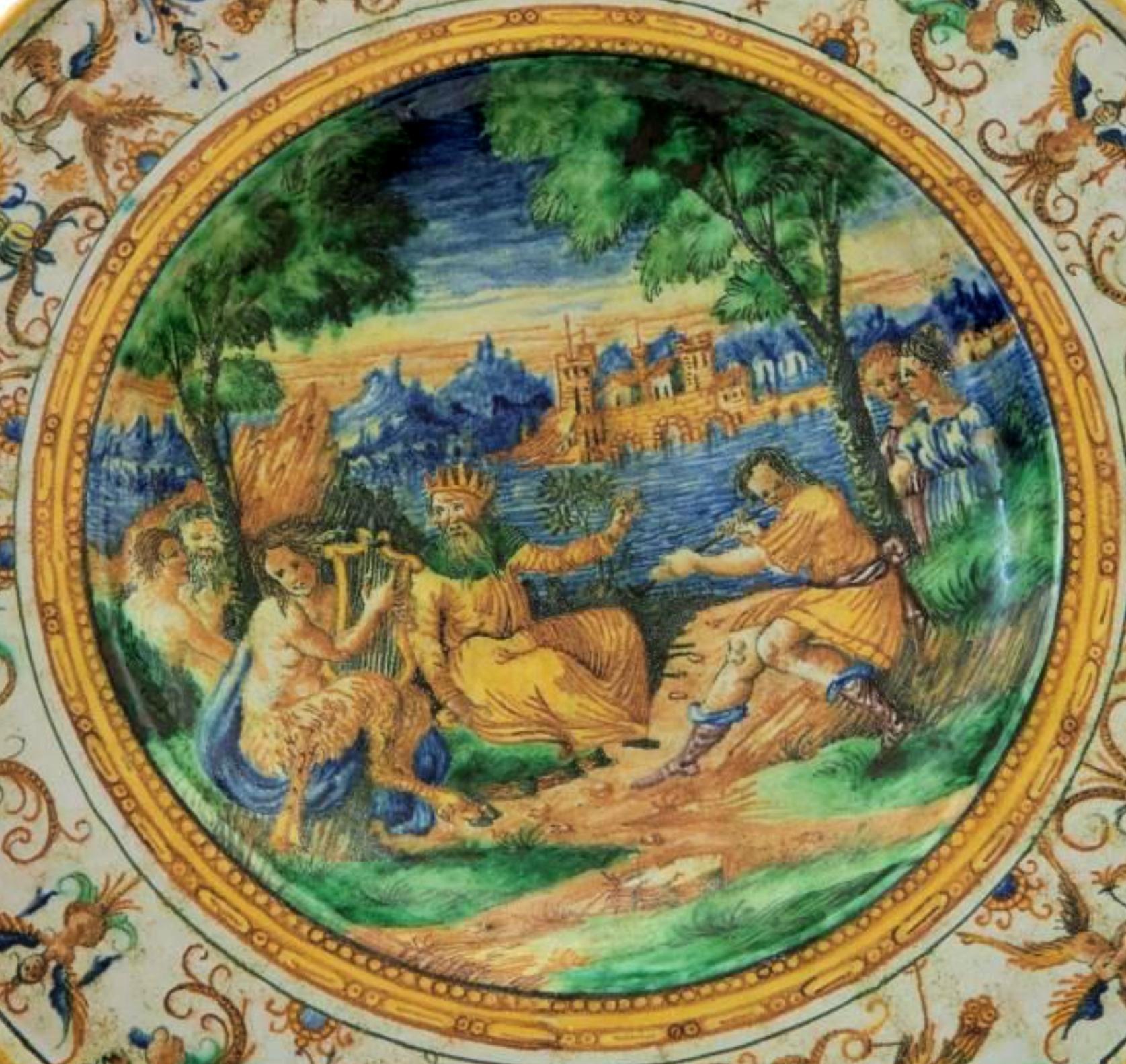 Important 19th Century Italian Parade Plate

Polychrome ceramic, with a wide brim, short frill, and a wide base. Reverse with ring support. Decoration on the rim with harpies and fantastic animals on an ivory background. In the recess, a scene taken
