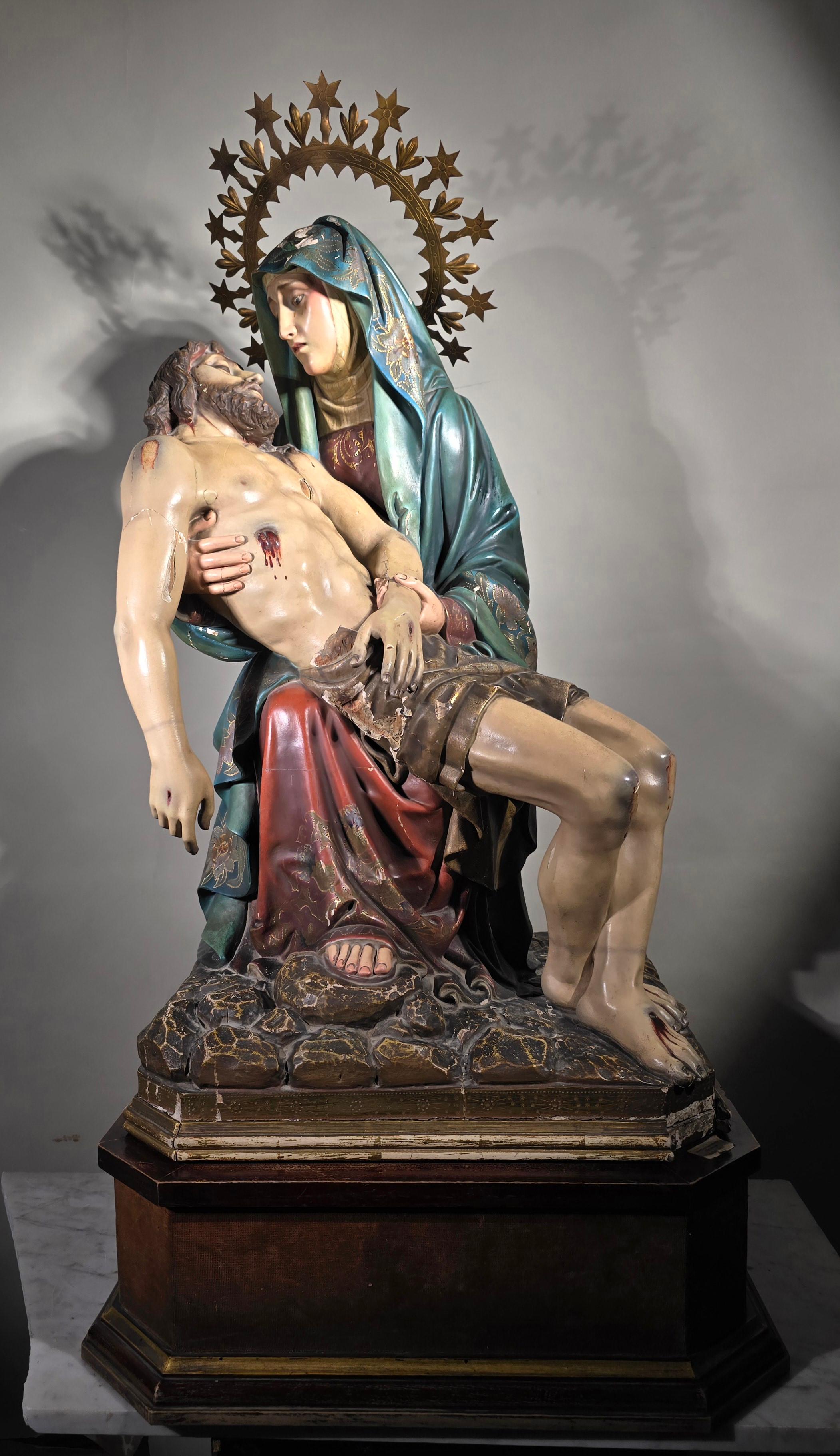 Tauchen Sie ein in die ergreifende Schönheit dieser bedeutenden Skulptur aus geschnitztem Holz und Polychromie, die die ikonische Szene der Pieta darstellt. Dieses Kunstwerk wurde wahrscheinlich im 19. Jahrhundert in Spanien hergestellt und ist ein