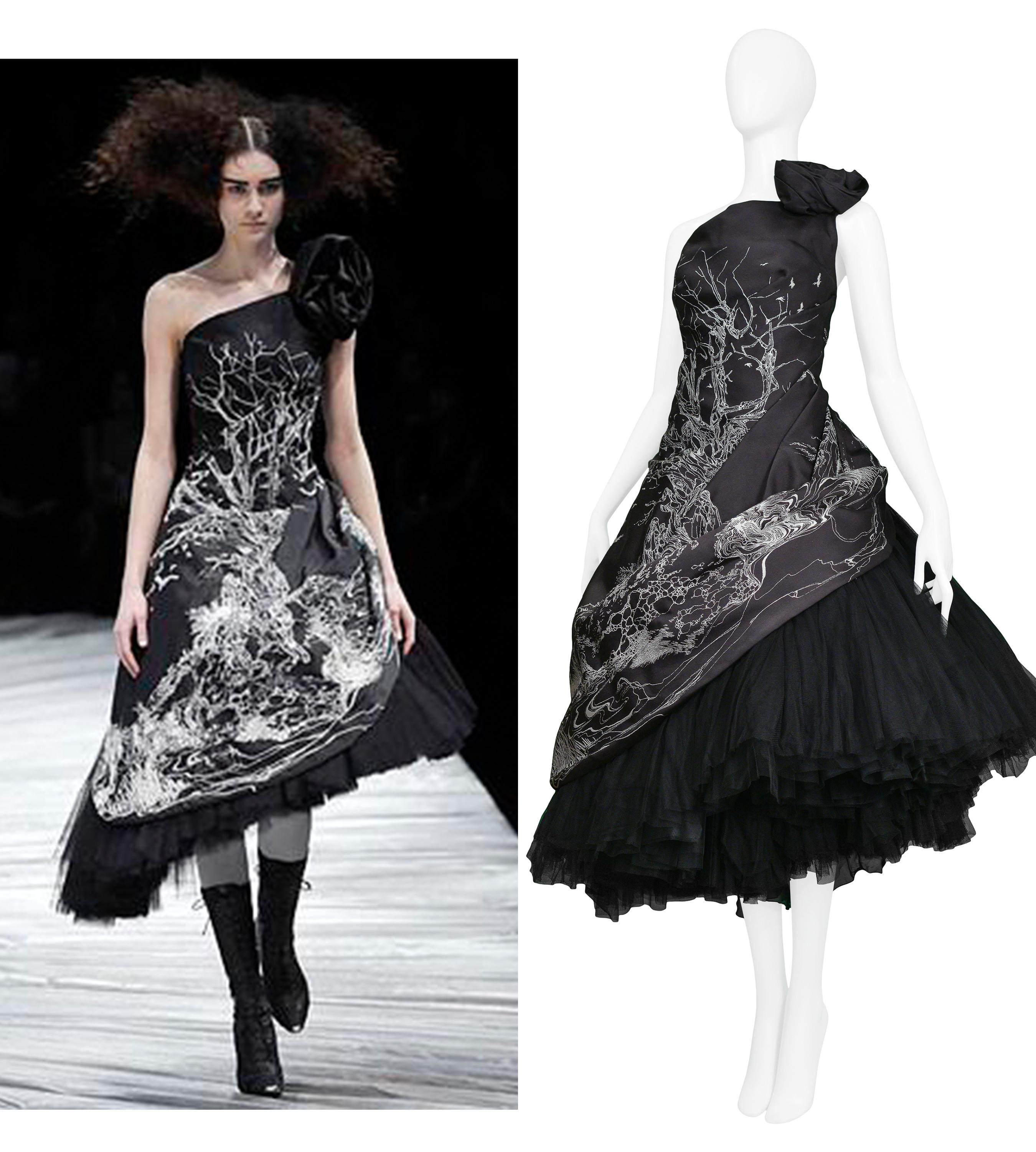 We are excited to offer an important vintage Alexander McQueen runway gown featuring a black satin taffeta asymmetrical strapless dress over attached layers of black heavy tulle, a black rosette, single strap, and center back zipper. The white