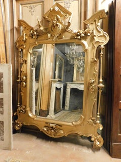 Importante e grande specchio riccamente intagliato e dorato con scultura, Italia
