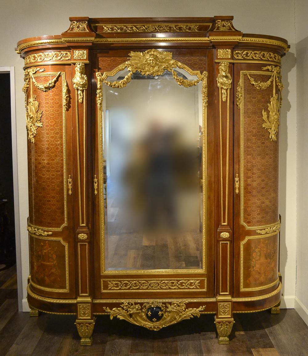 After the design of Jean-Henri Riesener (1734-1806) for the commode for La Chambre de Louis XVI a Versailles. Ormolu bronze mounts by Jean Rabiant with fruitwood marquetry and parquetry mahogany. Measures: Bedframe 59 H x 72.75 W. Armoire 9 H 5 x 95