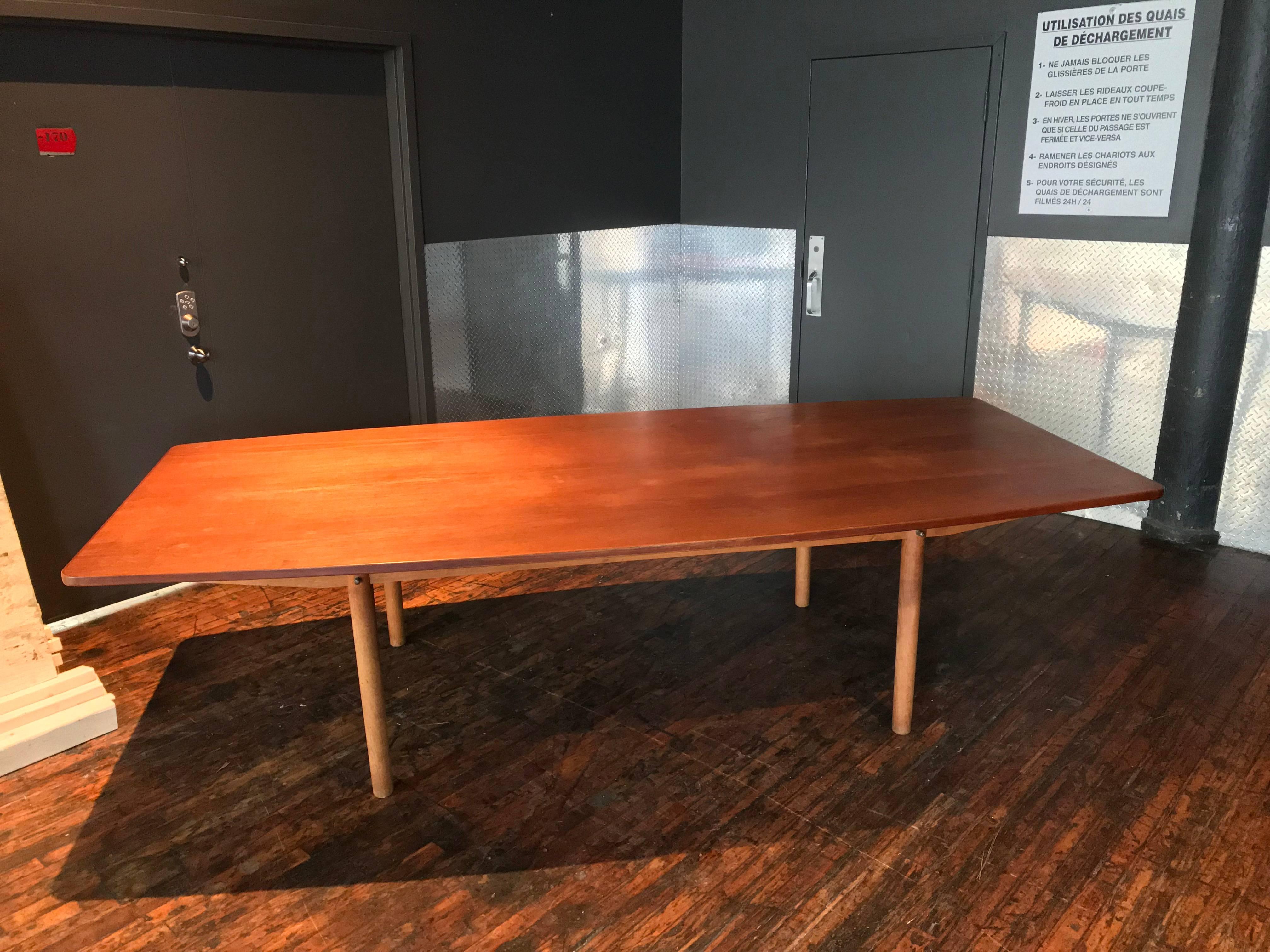 Very large teak and ash dining or conference table , the barrel shaped top showing a beautiful teak veneer on solid oak, the circumference of the top is finished solid teak trim, all resting on a solid oak four legged base.