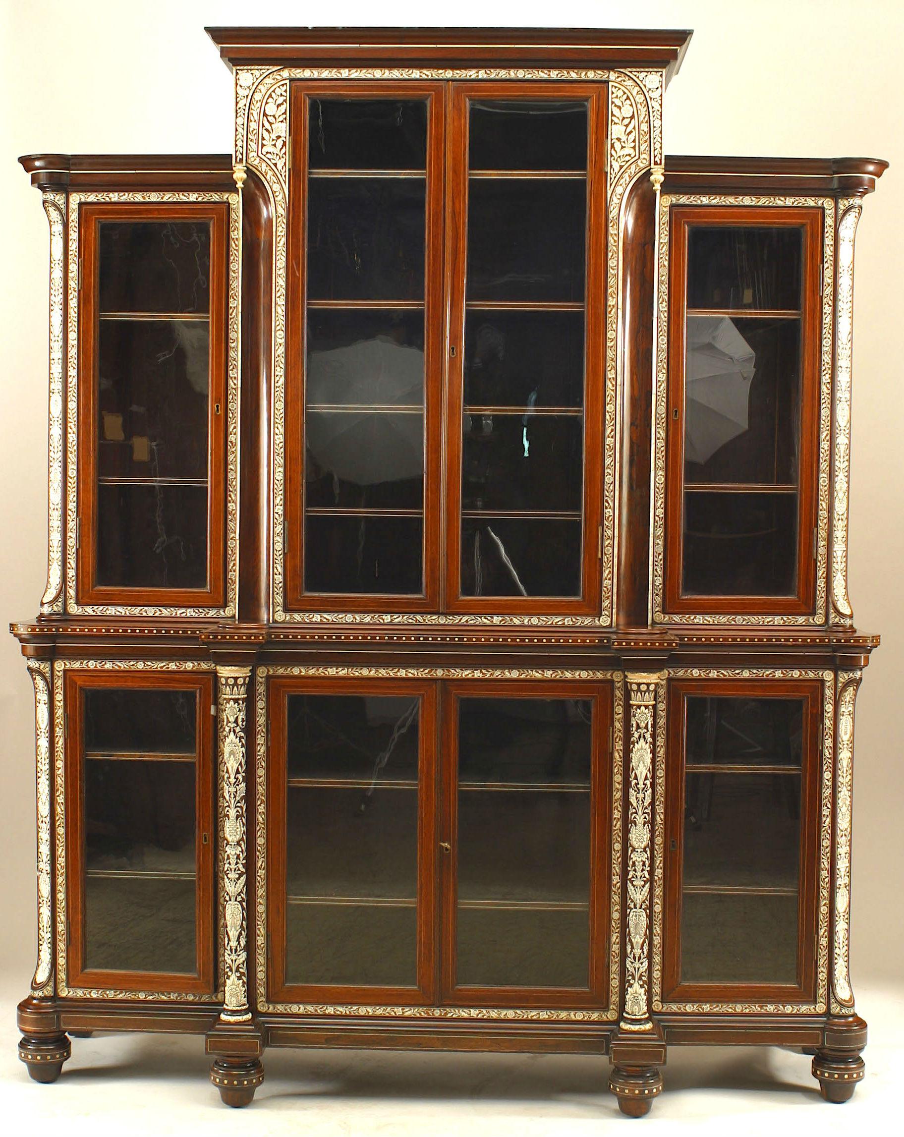 Nineteenth century Anglo-Indian breakfront cabinet most likely originating in the Vizagapatam region of British India. The rosewood cabinet is divided into three sections and eight shelved cabinets enclosed by glass doors and trimmed with inlaid and