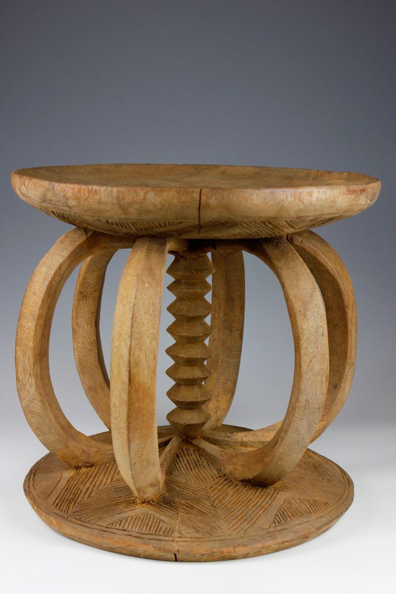 This large, rare Igbo title stool from Nigeria displays a wonderful sculptural form. 

The circular seat and base are connected by a series of beautifully curved supporting legs, which adjoin at the centre - meeting at the finely carved central