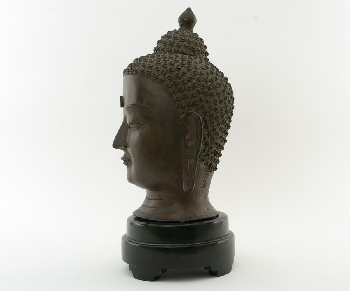 This is a wonderful head of Buddha showing a serene expression in downcast eyes. The workmanship is magnificent with the turquoise decoration and wood stand. The statue is signed on the back of the neck with Chinese characters.