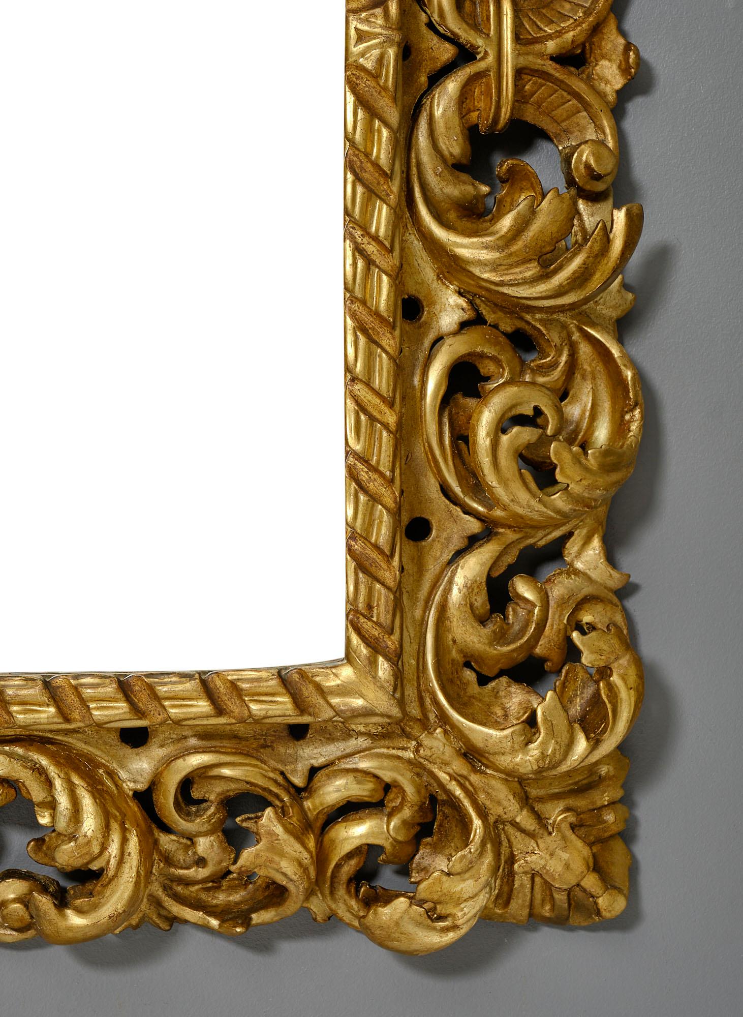 Grand mirror from Italy, 19th century. This piece is originally from a Tuscan palazzo. We love the rich decor of hand-carved acanthus leaves and scrolls in the stuccoed and hand-carved frame. It features 24 carat gold leafing and has been fully,