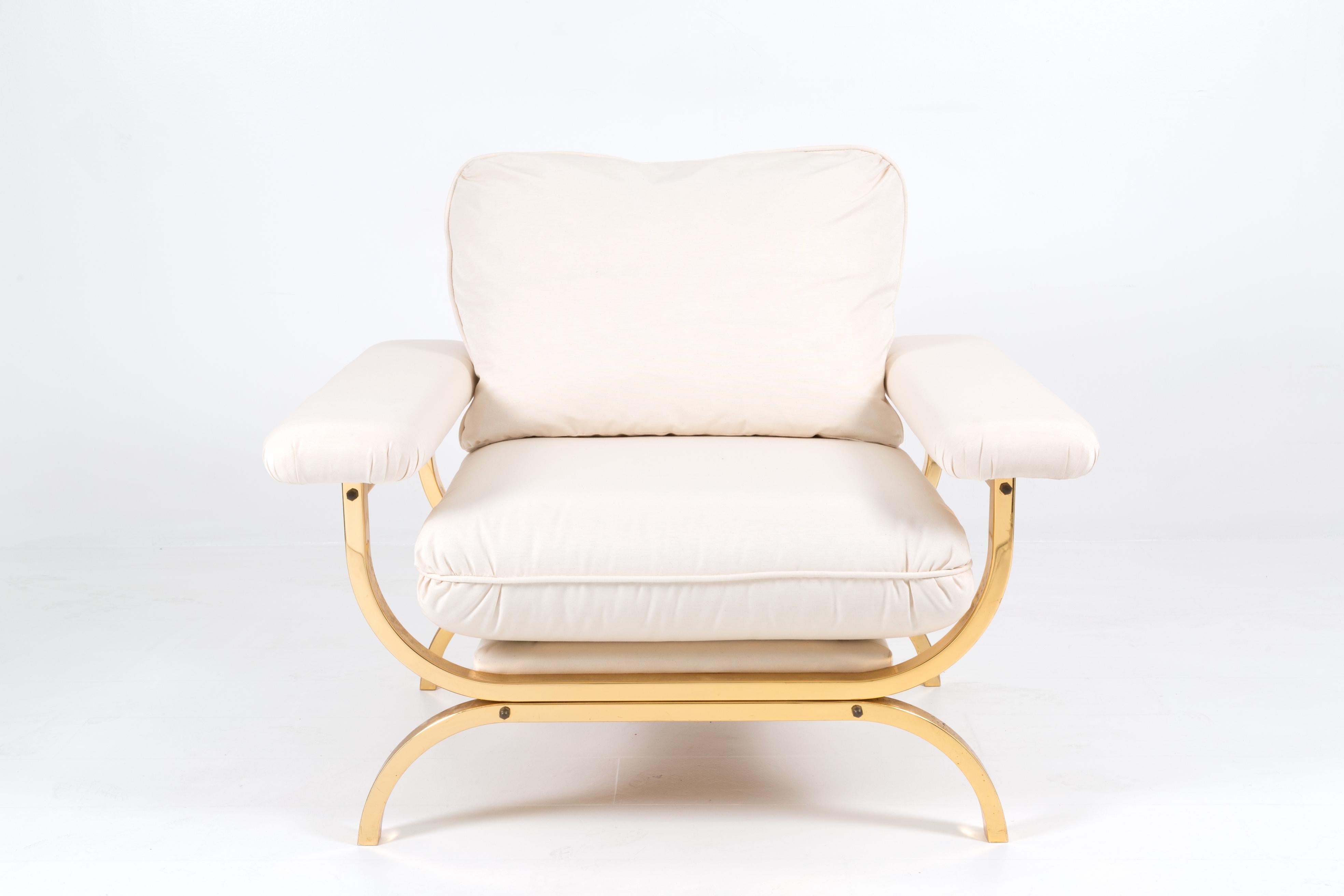 Important armchair made for Reza Pahlevi Shah of Persia by Maison Jansen in the 1950s. The majestic armchair is made with a brass frame and upholstered back with a white fabric cushion.  Anxhe its armrests are upholstered in white fabric. 
The