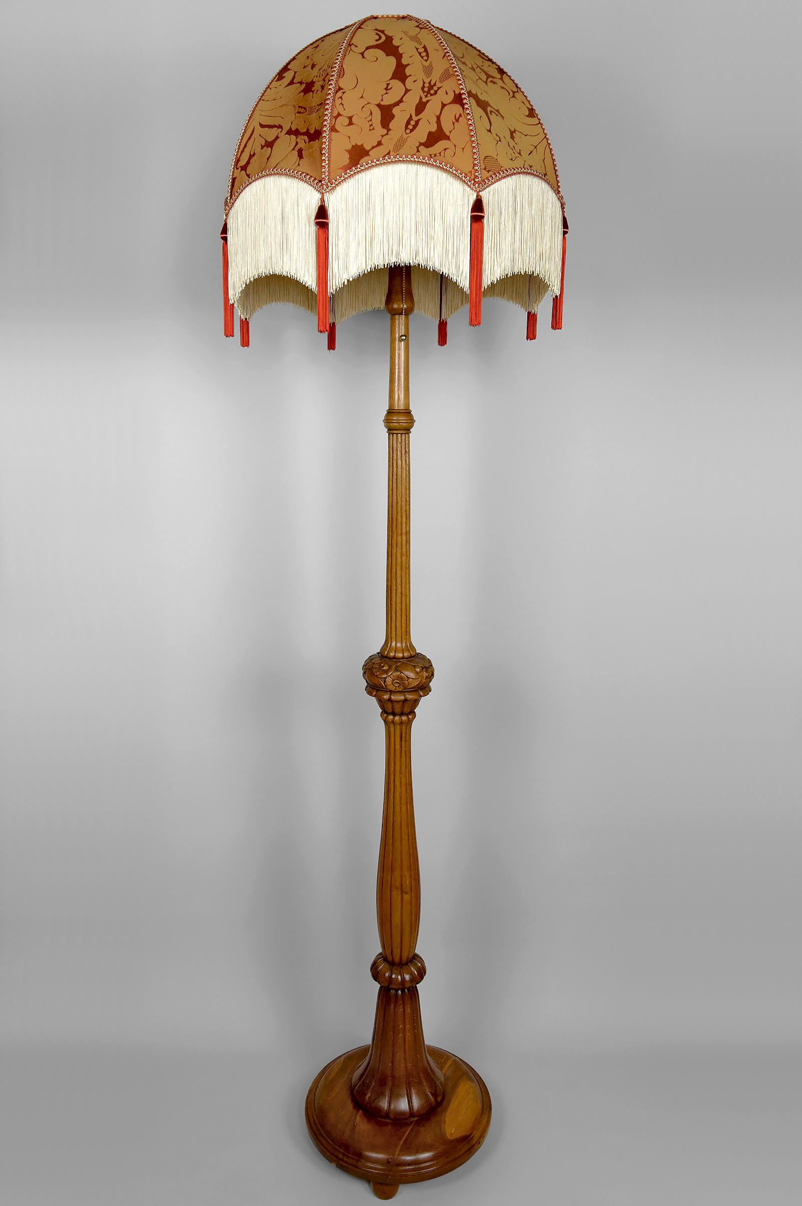 Questa magnifica lampada da terra Art Deco degli anni '20 incarna l'eleganza senza tempo e la maestria artigianale dell'epoca.

Realizzata in rovere massiccio intagliato, la lampada si distingue per le sue dimensioni imponenti e i ricchi dettagli